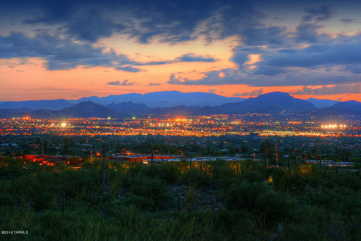 Ron Robinette southwest contemporary custom home with incredible views of Catalina Mountains & city lights. Almost 4,900 sq ft this well thought out home has huge picture windows, large rolling shutter on a west facing window. 2 ensuite guest quarters (one handicap accessible), den, lux master suite w/ fireplace, sitting room, & his and her closets. Mstr baths have new updated fixtures. Huge kitchen w/ semicircular island has brand new granite, 2 ovens, new stainless sinks & faucet, spacious wet bar w/warming drawer & 2 pantries. Outdoors enjoy the pool, water feature, spa, deep covered porches w/fireplace, grassy lawn and roof top viewing deck, with lighted access, to enjoy a 360 degree view of Tucson. 24 hour gated community.