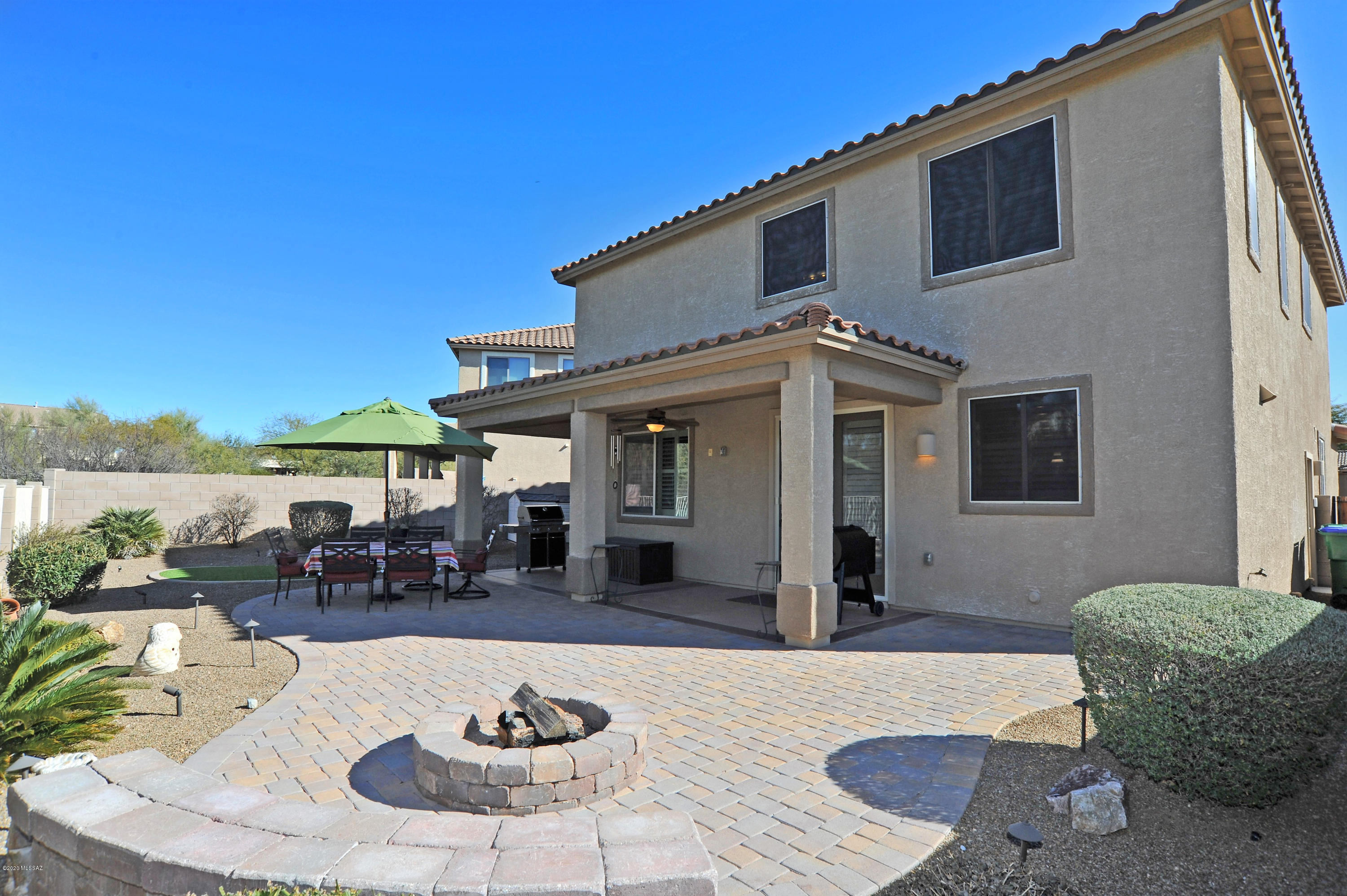 This magnificent Oro Valley home is waiting for you! The meticulously kept 4 bedroom + loft, is loaded with upgrades and amenities. Gourmet kitchen boasts espresso cabinetry, granite counter tops, stainless steel appliances, double ovens and a large walk-in pantry. Fully landscaped backyard is complete with large covered patio, pavers, fire pit and artificial turf. Windows and back French door all have plantation shutters with added solar screens on front and back windows. Lower level of home is completely tiled, carpet in upstairs bedrooms, 3 FULL bathrooms all with tiled shower surrounds, extended garage with epoxy floor, whole house water softener, new water heater... the list goes on and on. The desirable location is buffered on one side and back with common area for added privacy and also allows for easy access to walking trails, sought after neighborhood and charter schools, shopping, etc. This is a must see!