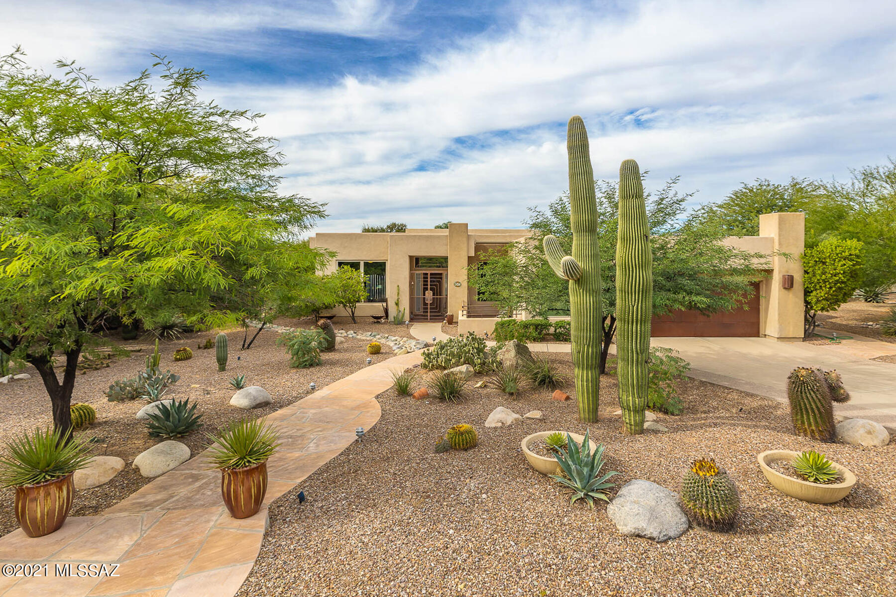 Spectacular 3BD/2BA (2,638 sq ft) home on a large, private lot in the heart of Oro Valley boasts quality details throughout plus resort-worthy yard. Enter through a gated front porch with  courtyard boasting Catalina views. Elegant foyer is flanked by a formal living room and stunning formal dining room with coffered ceiling & skylight. Beyond lies a Great Room with gourmet kitchen hosting granite counters, SS appliances, breakfast nook & island, plus walk-in pantry. Spacious Master suite offers patio access and luxury bath w/ dual vanities, jetted tub, walk-in shower and walk-in closet. Guest bedroom accesses rear patio. Retreat to a resort-style yard with heated pool, ramada, fireplace and BBQ island. Garage features built-in cabinets and a wide side extension. Professionally landscaped.