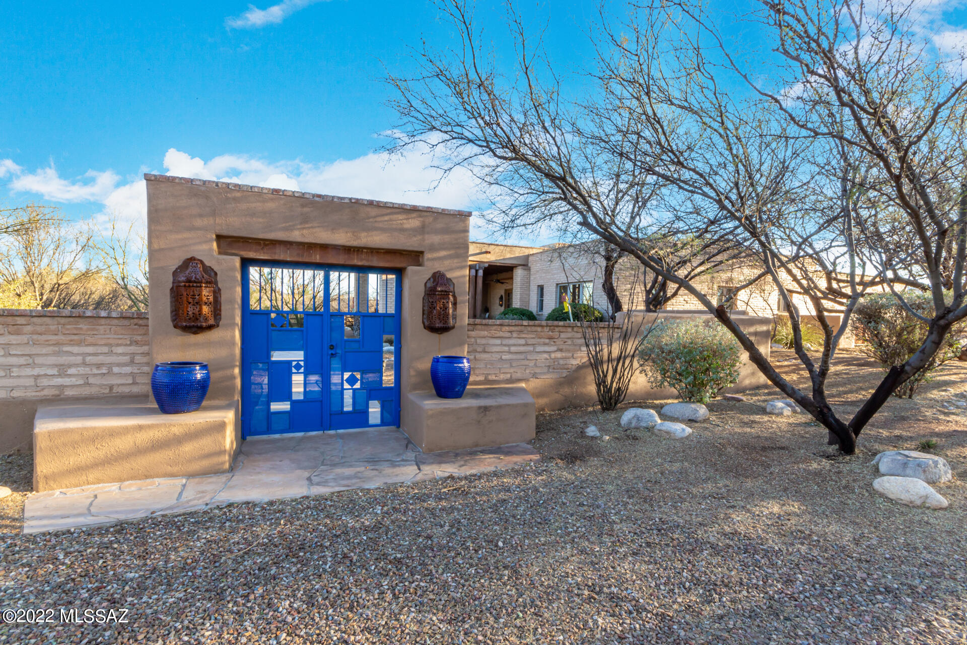 This Southwestern adobe hacienda sits on 2.19 acres (two lots) in the Tubac Valley Country Club Estates. The entrance brings you through an elegant, massive 1,200 sq. ft. covered porch/patio with seating areas, stone fireplace, and mountain views. Just inside the tall, french doors is the living room with fireplace and views through to the large, welcoming courtyard. Just off the kitchen, are both a large pantry and utility room. The custom bar area and dining room look out to the manicured yard and to the mountains.  At the other end of the house, the spacious main bedroom has a large ensuite bath, and the 2 casita style bedrooms have separate entrances from the home just off the courtyard. 2 car garage, private well. Well maintained, cared for, luxury home in the desirable TVCC Estates.