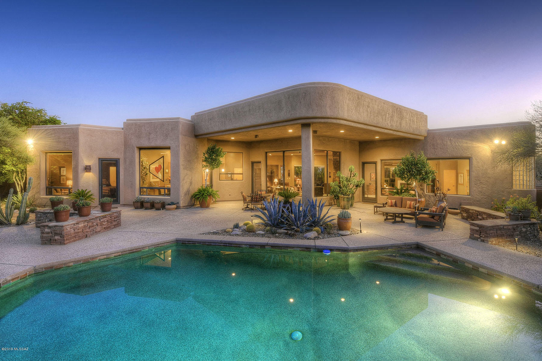 Outstanding Bill Diamond built southwestern contemporary with 3,255 sq. ft., three bedrooms including two master suites, in prestigious, gated Pima Canyon Estates in the Catalina Foothills.  Located on a .98 acre view lot, courtyard entry with exposed aggregate walkway and outdoor living area leads through custom iron front door into wonderful great room with soaring coved ceiling, walls of windows with mountain views, stacked stone fireplace and adjacent formal dining room with coved ceiling.  Gracious master suite offers two-way fireplace, sitting room, master bath with dual vanities, spa tub and walk-in closet.  Den/office has generous built-ins, Murphy bed and could be 3rd bedroom.  Kitchen features granite counters, gas range, center-island with breakfast bar, breakfast nook and wine frig.  Glorious rear yard has pool, spa, flagstone walkways, outdoor fireplace with stacked stone and banco seating, 3 car evaporative cooled garage and so much more.  See to appreciate.