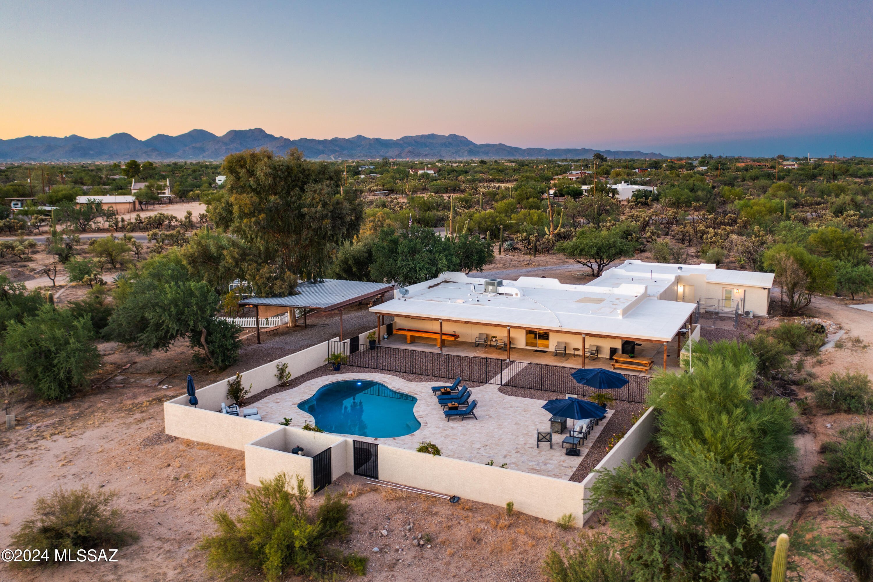 Welcome to your private desert retreat! Nestled on 3.34 acres, this serene 4-bedroom, 3-bathroom home offers stunning sunrise & sunset views, making every day feel like a getaway. Zoned for horses & perfect for those seeking space and tranquility, the property includes a bonus room, a 2-car extended garage w/ a 220-volt outlet, & an RV/4-car carport. The outdoor spaces are a dream w/ an enclosed, covered garden area, a sport court w/ lighting, a 40-yard turf area for endless recreation, & a new pool w/ luxurious travertine decking (2022). Inside, enjoy the beauty of completely renovated interiors featuring gorgeous, engineered hardwood flooring throughout, newer HVAC system, mini-splits, water heaters, & energy-efficient windows. This desert gem combines peaceful living w/ modern comfort & convenience, making it the perfect sanctuary for those looking to embrace the best of both worlds.