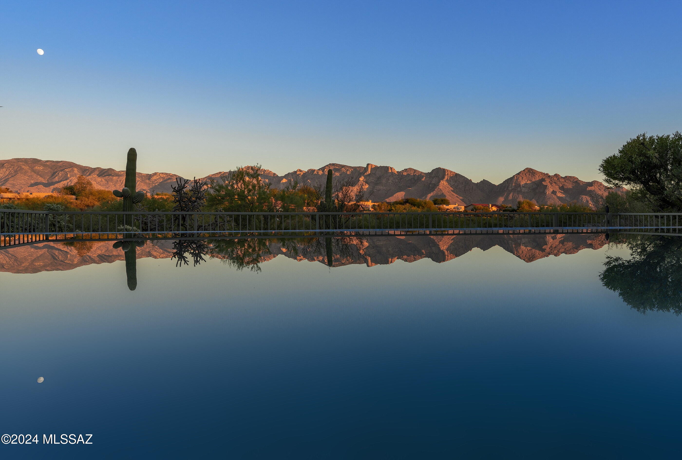 This stunning Oro Valley home checks all the boxes—and then some! The open, modern floorplan is flush with natural light, displaying Catalina Mountain views and the negative edge pool through brand new windows. Taupe concrete floors throughout are balanced by wood cabinetry for warmth, creating a timeless yet modern feel to this home. The open living space in the center of the house has an adjacent den/media room (and potential 4th bedroom), oversize picture windows and a gas fireplace.  Equipped with all stainless-steel appliances including a gas cooktop with a to-the-ceiling range hood, the kitchen features natural materials and a walk-in pantry with a glass-paned door. The kitchen and the attached dining area with built-in beverage fridge and serving counter also have spectacular view . Just off the living/kitchen is a convenient half-bath with modern vanity and a dramatic backlit mirror.  An office with built-in cabinetry topped with granite could also be craft room or exercise space. The generous primary suite offers a massive view window, access to the patio and a wood feature wall. Get ready to unwind in the primary bath complete with more jaw-dropping views, a soaking spa tub, walk-in freshly re-tiled shower and dual sinks, backed by another wood feature wall.  Two guest bedrooms are joined by a guest batheach bedroom with its own separate vanity room and shared access to the shower/lavatory. Rounded out by a wonderfully functional and aesthetically pleasing laundry room, a 3 car garage with epoxy coating and other thoughtful upgrades like a whole house water filtration system, your new home is the epitome of easy living. Primed for stargazing and wildlife watching, the magnificent outdoor space has the coveted panoramic Catalina Mountain views, a negative-edge pool with elevated spa, covered patio and lush natural desert beyond the view fence. Situated on a .84 acre lot with the back facing due east, this property offers privacy and close access to shopping, dining and other services.