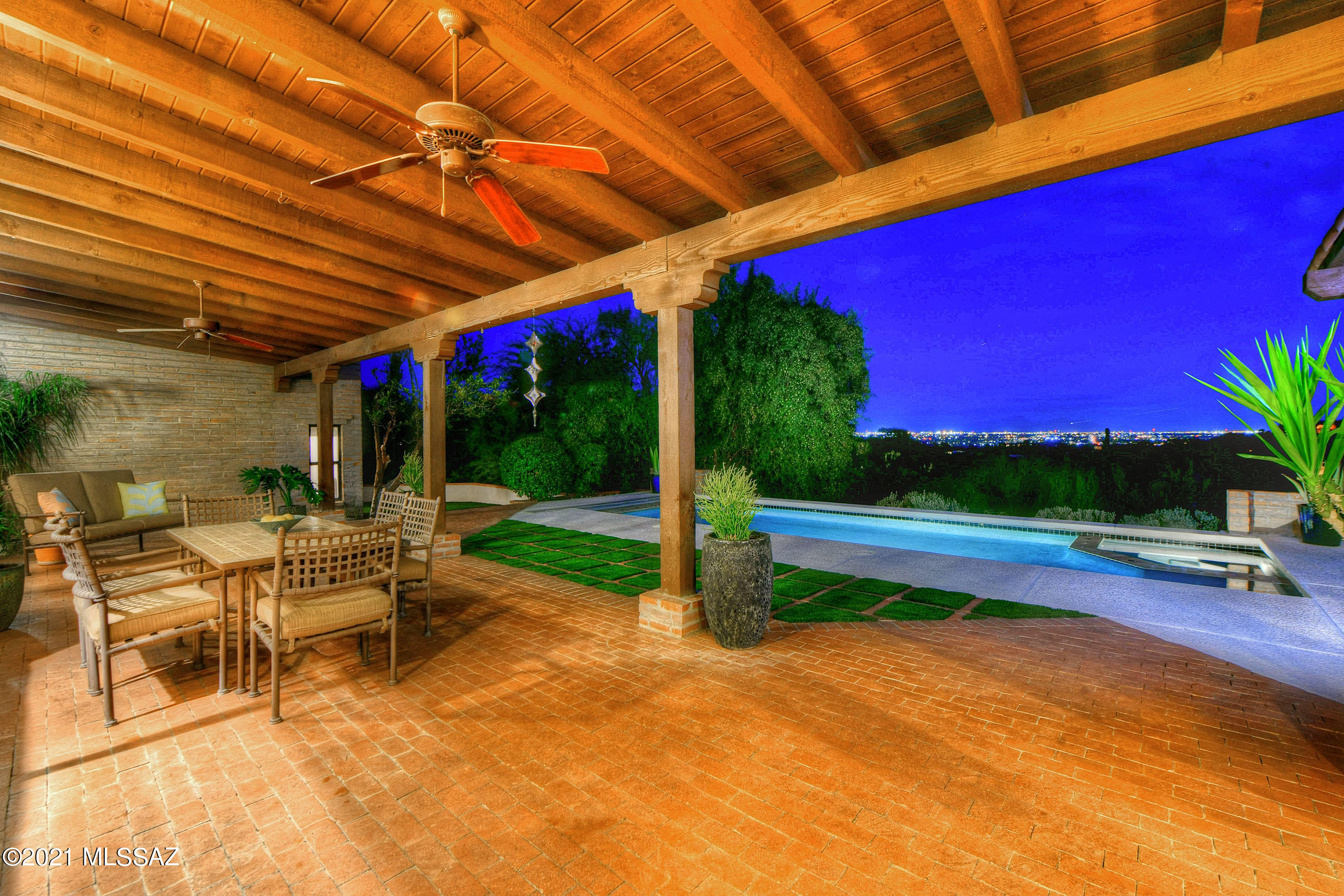 There is no need to leave home again as this spacious 5 bedroom, 4 bathroom home can accommodate all of your needs, from a private office space and home gym to a 300+ bottle wine closet and a resort style backyard. Open the double french doors in the peaceful living room and listen to the soothing fountain while savoring the view of finger rock on top of the Catalina Mountains.
The home is located in Catalina Foothills #10 which is one of the most sought after neighborhoods in Tucson due to its central location. The prestigious gated community is quiet and ideal for walking or biking with miles of open road loops to explore. 
The resort style backyard is the focal point of the house where you can relax in the serenity of the majestic Sonoran desert landscape. The yard is designed for year round entertaining with the protection of expansive covered patios and built-in Fire Magic grills during the summer and a fireplace and automatic pool cover to keep the pool and you warm during the winter. You and your guests will delight in the stunning mountain and city views that extend from the lush foothills through the city, culminating in the silhouette of the Santa Rita mountains during the day and dazzling city lights at night.
This modern, brick adobe house is designed with travertine and wood floors and high decorative beamed ceilings, illuminated by natural light from a plethora of sky lights placed throughout the home. Floor lights guide you to the large master suite with ten foot beamed ceilings and one of four gas fireplaces, the highlights of this enormous master suite with a bathroom to match. The master bathroom accommodates couples with two sinks and vanity areas, a walk-in shower for two and a jetted bathtub, which makes this master bathroom not only cozy, but infinitely functional as well.
The entertainer's dining room features warm cherry cabinets and granite counters with a built-in warming drawer and Uline wine and beverage refrigerators. Diffuse light descends from the recessed ceiling with inlaid stained glass that brightens the dining room in parallel with large windows and a french door, that leads to the relaxing backyard.
The kitchen is bright and efficient with white cabinetry, stainless appliances and endless granite counter space with bar seating. Cooking is enjoyable with two large ovens, Sub Zero refrigerator and Bosch dishwasher all situated around a large cherry island for ease of preparation and ample storage for every kitchen accoutrement.
The house is well maintained and has recent upgrades installed in 2021 including the flat and tile roof, dog-friendly turf, Kinetico soft water system, two smart water heaters and much more.