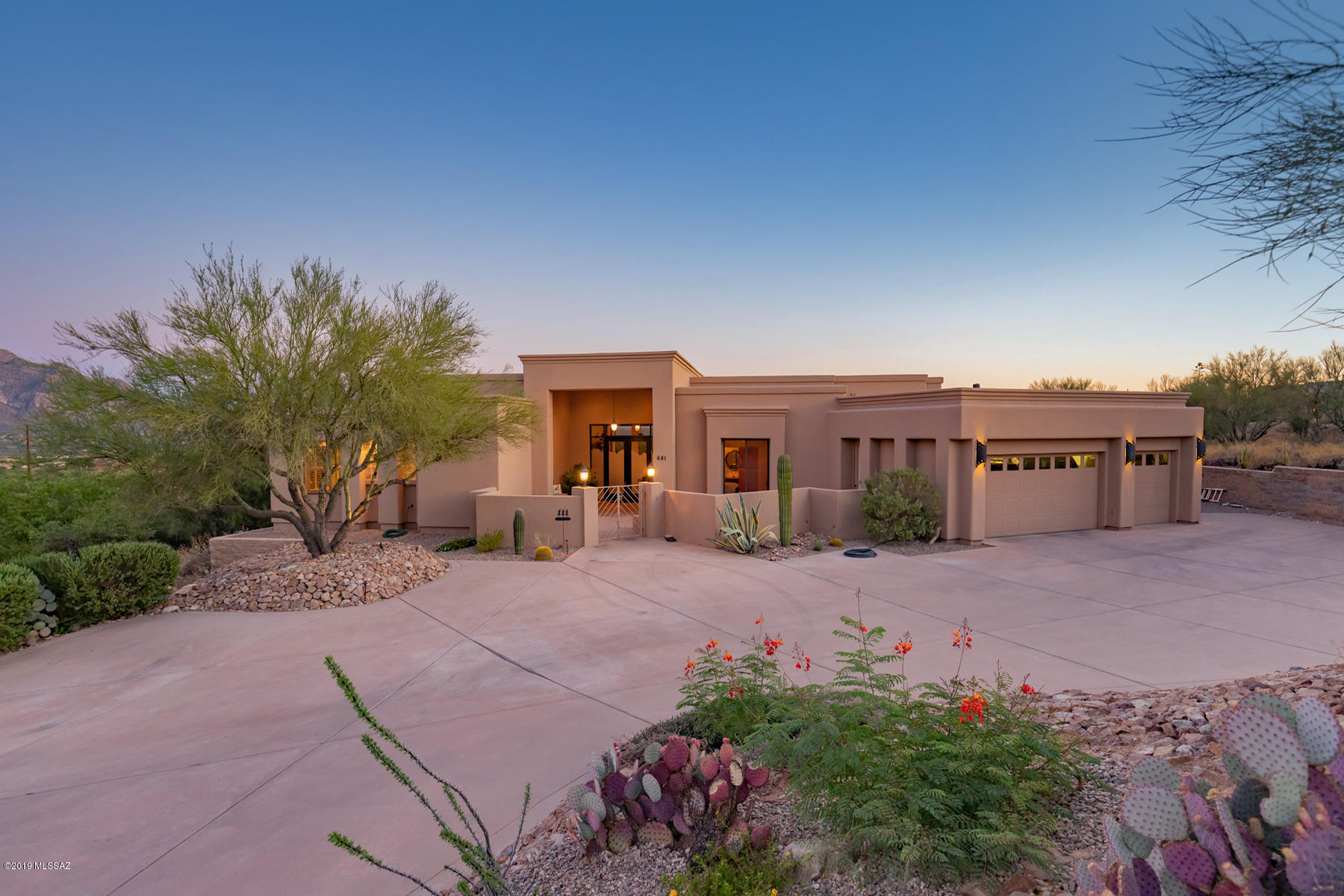 It was ''love at first sight'' for the now-sellers of this softly contemporary home tucked away on a quiet cul-de-sac with lovely neighbors in gated Coyote Ridge in Oro Valley. The sweeping mountain and city views from many large windows throughout the home are majestic, as befits a home located on Majestic Ridge. The home is airy and light, with large accommodating rooms that envelope with warmth and graciousness. The views are mesmerizing, with Pusch Ridge as a highlight, along with much more of the Catalina Mountains, downtown Tucson's city lights and the Tucson and Santa Rita Mountains across the Valley. From the handsome courtyard entry and through the artistic frosted glass double entry doors, visitors are enthralled by views through multiple walls of windows of the lush rear yard and lovely classic turquoise fresh-water pool with its elegantly flowing water feature, and the mountain views beyond. It's just a lovely setting. The home is open with an easy flow from the comfortable living room and dining area and into the cozy family room and inviting kitchen, perfect for today's casual Tucson lifestyle. Most of the home has handsome travertine flooring, with travertine counters throughout from kitchen to wet bar to bathrooms. Easy clean-up! High ceilings have accommodated tall holiday trees for many warmly remembered family gatherings. There are multiple areas of built-in shelving for both books and art throughout the home. An office area has an attractive and functional built-in desk with shelving, file drawers and printer pull-out. The kitchen is open and well-lit, with skylights and mountain views. With a butcher block-topped island and prep sink, Gaggenau 7 burner gas/electric stove, large walk-in pantry, built-in Kitchen Aid refrigerator, handsome and abundant cabinetry and plenty of travertine counter space, the chefs will enjoy being here. An adjacent family room is cozy, with a gas fireplace set in more handsome travertine. The spacious master bedroom has coffered ceilings and more walls of windows for enjoying those glorious mountain views, and a comfortable sitting area. Slider doors lead out to a private patio. In the master bath, enjoy long double travertine counters, an oval Jacuzzi tub and more incredible mountain views sweeping across the Catalinas (and plantation shutters for privacy). A very ample walk-in closet provides terrific built-in shelving and drawers. Another smaller bedroom is nearby with sliders out to the front courtyard. Two additional bedrooms across the home both are spacious, with private bathrooms; one bath opens to the rear yard for use by pool visitors (no dripping kids wandering through the home!), while the other has a lovely small oval tub set in travertine. Both have walk-in closets. The rear yard is a delight, with lush plantings including roses, colorful bottlebrush tree and a fabulous lemon-orange tree that produces prodigiously all winter. Of course, the in-your-face Pusch Ridge views as well as those of the city lights and mountain ranges across the valley are spectacular. With apx. 1700SF of covered patios wrapping around the rear of the home, and that large gorgeous pool, there is plenty of room to entertain in a relaxed yet elegant style. A great and private neighborhood, near to all of the best of Oro Valley's excellent amenities and schools including the new STEM school, top-notch medical facilities, great hiking/walking/biking, easy access to the Tucson Loop, and offered at an excellent price. What are you waiting for, call today to arrange your private showing!