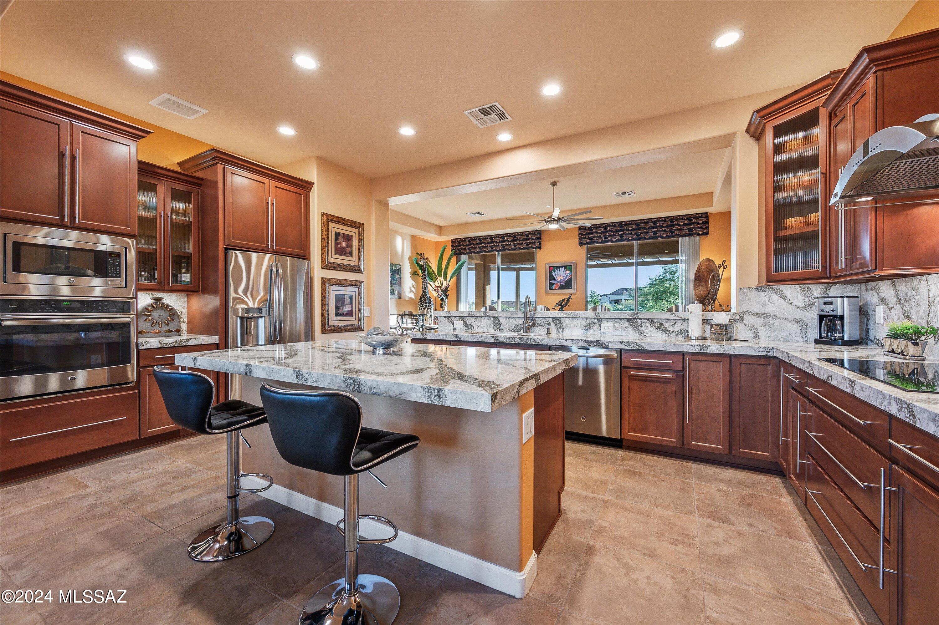 Nestled within The Preserve, this secluded property showcases breathtaking Catalina Mountain views. The Sabino model boasts a meticulously crafted layout with split bedrooms, each with ensuites for ultimate privacy. A tastefully updated powder room, spacious den, and airy open-concept design enhance the allure. The generous great room, featuring a warm gas fireplace, effortlessly connects to the impeccably remodeled kitchen. Revel in upgraded cabinets, quartz countertops, stainless steel appliances, and a substantial island, complemented by a walk-in pantry and ample dining area. Conveniently located, the laundry room offers ample storage upon entering from the garage.
The 3-car garage offers abundant room for vehicles, recreational gear, and storage needs. Outdoor tranquility reigns, with a front patio perfect for sunrise admiration, while two distinct back patios, one covered and one uncovered, along with an extended ramada and flagstone patio, set the stage for effortless entertaining. The low-maintenance landscaping features a shade-providing tree, ideal for relaxation amid breathtaking views. Additionally, the side yard offers potential for garage expansion, a casita addition, or even a pool installation.
SaddleBrooke stands as a premier active adult community, boasting resort-style amenities including pools, golf courses, tennis and pickleball courts, clubhouses, and much more, promising a lifestyle of leisure and enjoyment.