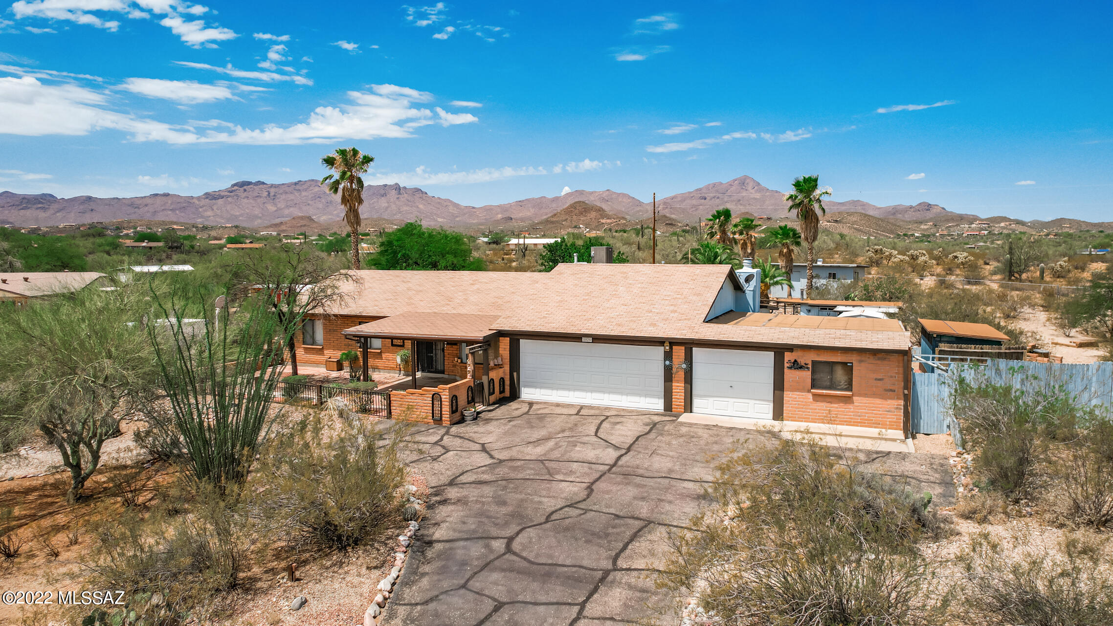 Welcome to your Westside Gem! Pride of ownership reflected with this well cared for home. Situated on a hilltop with a covered entryway to enjoy the morning sunrise & mountain views. Your view from the backyard will not disappoint either with amazing mountain views from your landscaped yard, which include a drop-in pool, hot tub, 2 storage sheds, a garden shed, greenhouse, built-in BBQ grill, horseshoes pitch, and a basketball court on the lower level of the property. Interior features sunken living room, great room w/fireplace off kitchen plus a bonus room. 3-car garage with a workshop. Roof is 6 yrs new & HVAC 2 yrs new. Excellent home for entertaining, and lot allows for horses! Easy access to I-10, downtown, UA and Pima College.