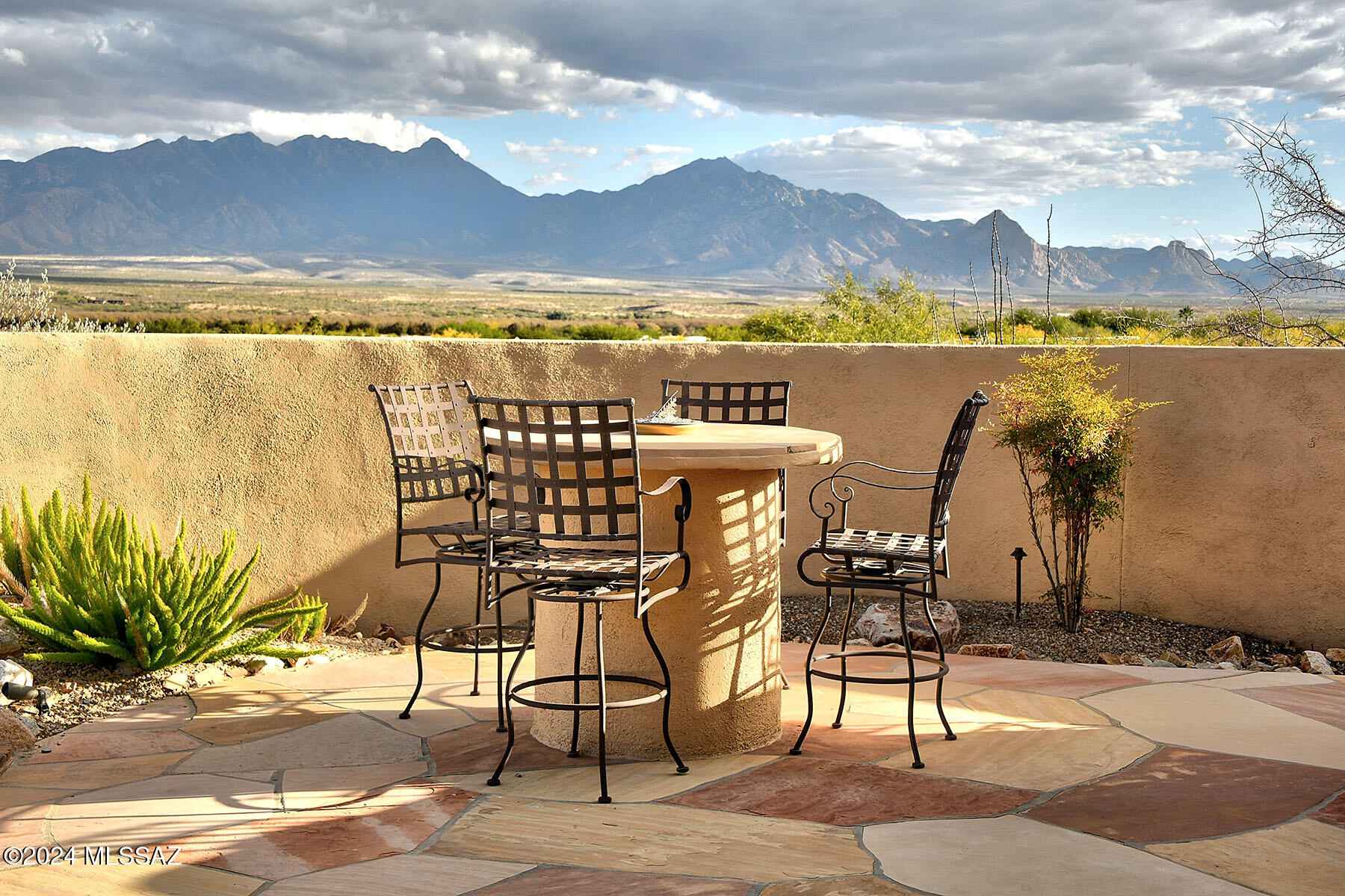 Located in a prestigious gated luxury community with NO AGE RESTRICTIONS, this home features some of the best unobstructed panoramic views in town! Perched high on an elevated 1.7 acre lot , features include 3 bedrooms, 2.5 bathrooms, an open floor plan with soaring ceilings and an expansive walls of windows so you can experience the breathtaking views whether you're inside or outside. Tastefully upgraded with exquisite architectural details, rustic wood beams,  8-foot doors, plantation shutters, and gorgeous ceiling fans. The gourmet kitchen is a chef's delight with stainless steel appliances, a gas cooktop and knotty cherry cabinetry. Tile flooring in living areas and fresh Berber carpet in the bedrooms.  Step outside onto the expansive covered east-facing back patio that wraps around to the south side of the home and includes an outdoor kitchen...ideal for dining and entertaining. Enjoy the soothing sounds of two water features, plus a walled backyard with ample space for gatherings or just relaxing. Two gas fireplaces, one in the great room and one on the patio. All that plus a 3 car garage! Surrounded by desert beauty and mountain ranges, this spectacular home offers the finest in luxury desert living.