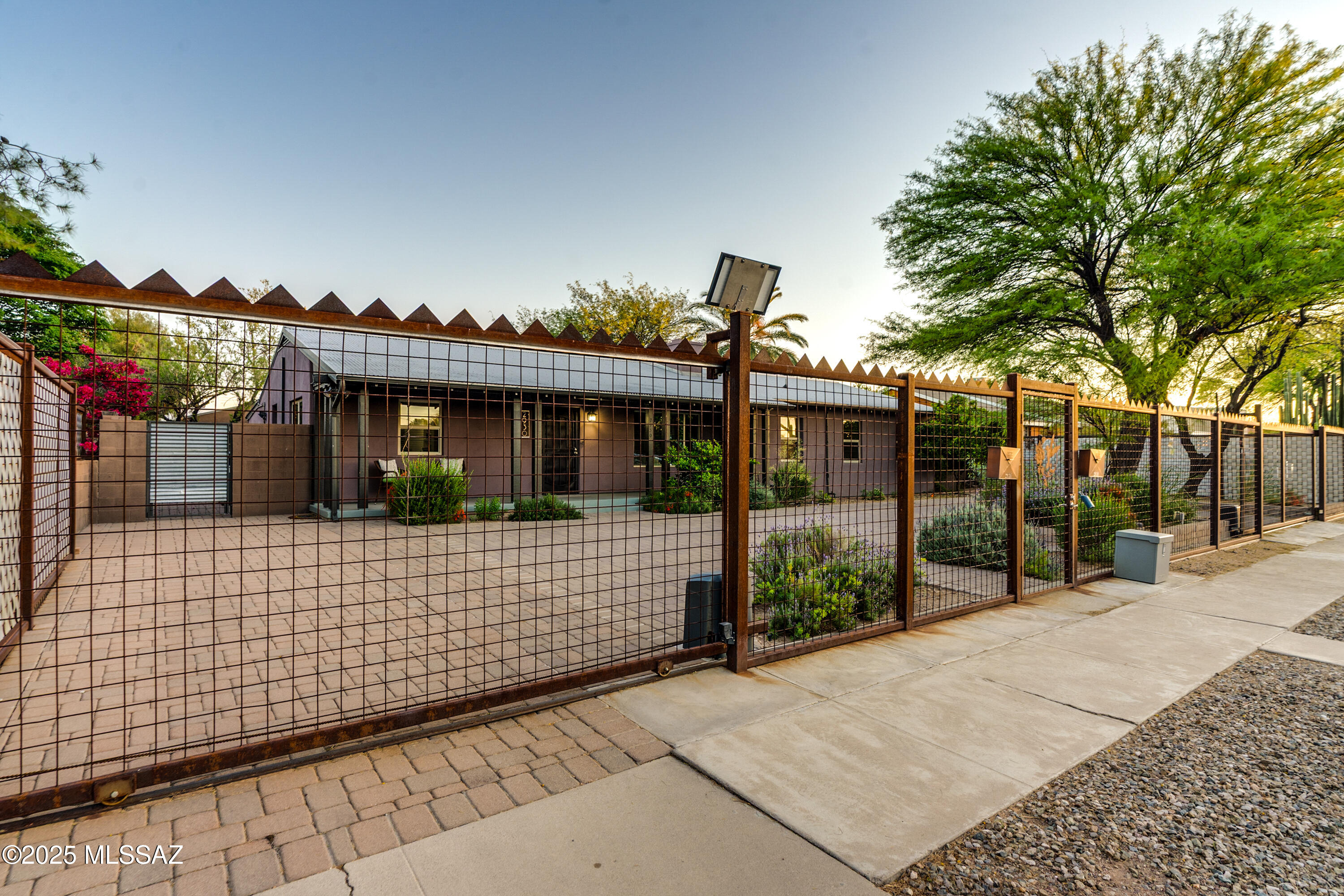 Unique Sam Hughes Compound available!  Main house features 4 Bedrooms, 3 beautiful bathrooms, 1988 square feet. Home has been lovingly updated including Kitchen, flooring, bathrooms, double pane windows, addition of custom metal fence with motorized gates, extensive pavers for the circular drive providing ample off-street parking. Thoughtfully landscaped through out with raised flower beds, pruned trees and more. Guest House 1 offers 548 sq ft and is a Studio with brand new ceramic wood styled floors, kitchenette, updated vanity/mirror in the bathroom and a new water heater. 3 Carport Spaces available in the alley and provides access to GH 1 and GH 2.  Guest house 2 (1358 sq ft) is a two story 3 bedroom. 2 bathroom home with second story balconies to take advantage of the Mountain views. All three homes have Metal roofs for longevity and peace of mind. The backyard features an oversized Ramada, custom pavers, raised flower beds, beautiful tree for shade in the summer, artificial turf, play set and hot tub.  Even through there are 3 homes located on the 1 lot, each structure has private outdoor areas available.  This phenomenal property is located just down the street from Himmel Park, walking distance to coffee shops, dining, and transportation and not to mention just around the corner from University of Arizona!  Whether you are looking for generational living, live in one and rent the others to offset cost, or an investment property- this home is one you should see in person!
