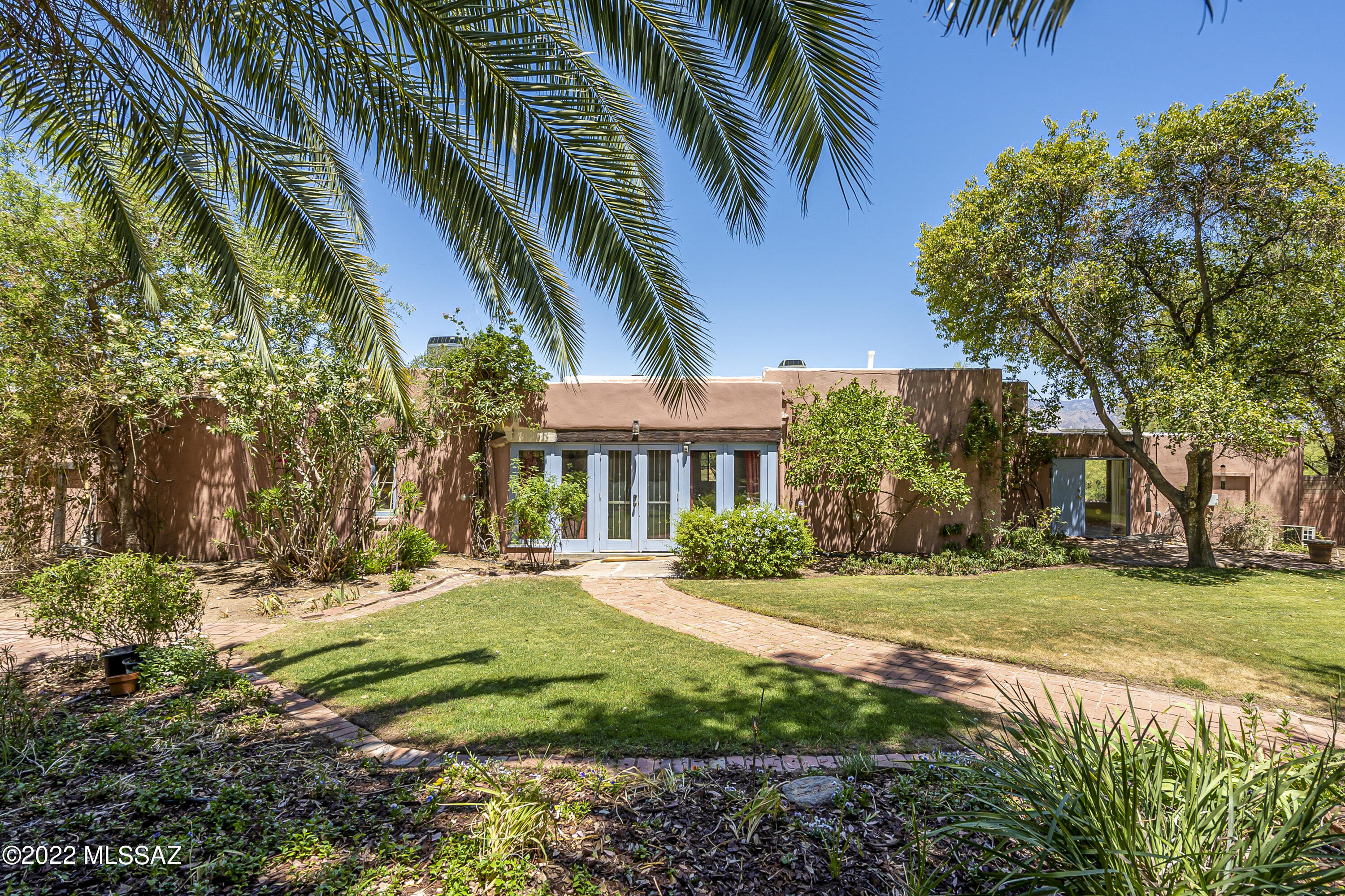 A charming architecturally and historically significant compound with irreplaceable gardens and handsome Catalina Mountains views is now welcoming its first new owners in over 40 years. The welcoming, rambling, and one-of-a-kind home and gardens are part of the Indian House Community Residential Historic District, believed to date back to the 1920's; the home is considered an example of Pueblo-Revival style. Thick adobe walls, original vigas (thick wood beams), and original lintels (exposed wood above doors and windows) found throughout the home exemplify elements of this style. Known historically as The Carr-Newell House, but today perhaps more aptly named ''The Garden Home'' in recognition of the stunning gardens surrounding the home, this property fits for families, entertaining, multi-generation, or professionals desiring a spacious home office with a private entrance.

Upon entry, be prepared to be enchanted with the huge main salon and smaller study with views out to the numerous outdoor living spaces that seamlessly connect and integrate within the natural desert landscape. Extensive brick pathways lead to charming shaded brick patios lending themselves to chilled lemonade and a cozy chat on a warm afternoon. Irrigated flowering gardens and hedges hide behind brick enclosure walls, with shade from ancient and fragrant eucalyptus, olive, kumquat, and cypress trees, one housing the possibly cutest treehouse in Tucson! Beyond is the gated enclosed pool, two-bedroom original casita, and circular ramada, another shady spot for a respite on a warm day by the pool. 

The kitchen and breakfast room enjoy views of the Catalinas overlooking a charming garden morning courtyard. There are new granite counters, a Viking stove and oven, and a generous butler pantry. A large bedroom or "bonus room" nearby looks out to the "Desert Garden", also fully enclosed. The dining area has been home to many large parties and holiday dinners, while the garden has welcomed several weddings. Two additional bedrooms, one with a large, remodeled bath featuring a steam bath and cedar closet, and the spacious private office with its views of the Catalinas and the rear gardens, complete the interior of the home.

Perhaps the current owners can best describe this unique property: "...given the fact that we have both passed the eighty mark and not likely to be up for the moving adventure for much longer, we have decided that we will put this wonderful oasis, this Shangri-La, this quiet haven in the middle of Tucson where road runners, bobcats and javelinas freely roam, where quail, cardinals, owls, doves and hummingbirds nest and play, into the hands of a new and younger family who will treasure the unique setting and the gracious home. And who knows, make it even better."

An additional 1.3 Acre adjoining undeveloped parcel is also available. This area has been occupied by many interesting historical figures, including the pianist Van Cliburn from 1960-1990 and many professors, lawyers, artists, and even a retired rancher. The home is a private sanctuary yet close to the University and Tucson's finest dining, cultural events, and entertaining, and medical facilities. A lengthy history of the Indian House Community Historic District is available and provided to the purchasers of this unique Pueblo-Revival style home. Please call for a private showing. As an added bonus, the seller will consider carrying the financing with 20% down!!