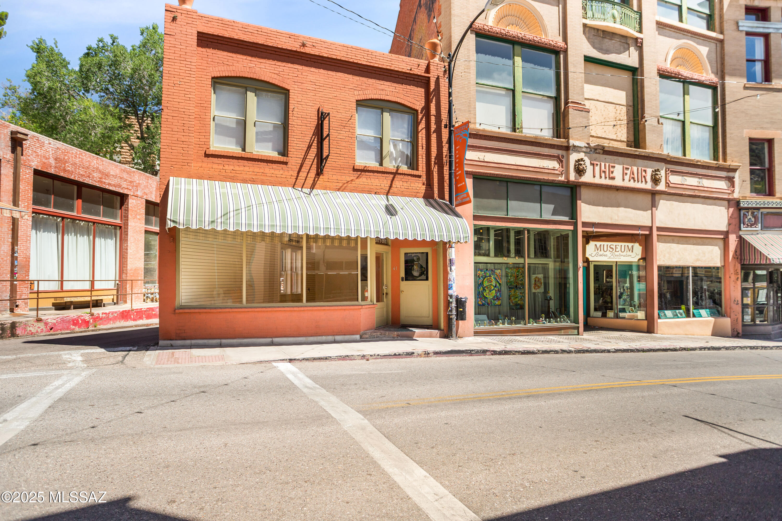 Historic 1906 Gem in the Heart of Bisbee with Mixed-Use & Residential Potential
Located in the Bisbee Historic District--a designated National Historic Landmark--this two-story brick building captures the essence of Bisbee's rich mining-era heritage while offering exceptional flexibility for investors, creatives, entrepreneurs, or those seeking a truly unique residence.
Featuring a recessed entry and arched second-story windows with decorative radiating voussoirs, the architecture reflects the timeless character of Old Bisbee during its peak mining years. Zoned CM-2, the property allows for both commercial and residential uses, opening the door to a variety of possibilities including live/work space, boutique lodging, artist lofts, gallery space, residential conversion, or mixed-use  income production.
The building offers approximately 733 sq. ft. per level, plus a basement, creating three distinct opportunities within one remarkable property.

Main Level - Retail / Commercial / Creative Space
A vibrant street-level storefront currently occupied, providing immediate income with potential upside through future rent increases or adaptive reuse. Positioned on bustling Main Street, this space enjoys strong visibility, foot traffic, and long-term appeal for retail, studio, café, gallery, office, or live/work concepts.

Second Level - Residential / Short-Term Rental
The upstairs level is currently configured as a fully furnished Airbnb-style unit featuring an open, airy ambiance with stylish décor that conveys with the sale. Guests enjoy picturesque Main Street views, making this a highly desirable short-term rental. Alternatively, the space could easily serve as a private residence, artist loft, or owner-occupied living quarters above the commercial level below.

Basement - Speakeasy / Studio / Expansion Opportunity
Featuring beautiful brick floors and historic character, the basement is currently used for storage but offers compelling adaptive reuse potential. Ideal for a speakeasy, wine bar, art studio, workshop, boutique retail, lounge, or additional residential expansion, this level adds significant value-add opportunity rarely found in historic downtown properties.

Investment & Lifestyle Appeal
With multiple income streams, flexible CM-2 zoning, and residential potential, this property appeals to both investors and lifestyle buyers seeking an authentic Old Bisbee experience. The combination of historic architecture, tourism-driven demand, walkability, and adaptive reuse possibilities creates a rare opportunity to own a true piece of Bisbee history while unlocking substantial future upside.
Whether envisioned as an investment property, boutique mixed-use project, live/work residence, or creative retreat, this property blends timeless character with modern flexibility in one of Arizona's most unique and culturally rich communities.
Don't miss the opportunity to own a landmark property in the heart of Old Bisbee--with built-in charm, income potential, and endless possibilities.