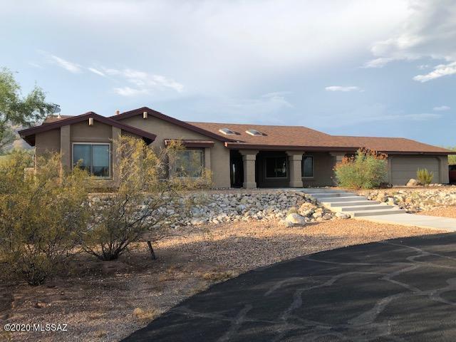 Beautiful mountain views from enclosed rear yard with a covered patio overlooking the pool. Back walled yard and is very private. Kitchen has granite counter-tops, s/s double ovens, new s/s dishwasher, and five burner upgraded gas stove with s/s island hood. Breakfast bar, room for a kitchen table and a separate formal dining room. FR is conveniently located adjacent to kitchen. Bathrooms feature granite counters with new under mount sinks. LR has a wood-burning fireplace . Master BR has a walk in closet. Glass doors from Master open out to patio/pool. 5th BR has its own separate entrance and A/C. Home has triple pane windows, fairly new 5 ton 15 seer A/C unit, new roof 8/2020. Brand new tankless water heater, new baseboards installed, walls have updated texture. repainted.  Long asphalt driveway was recently resealed with two coats in July 2020, large backyard pool was re-plastered in May 2020.  Poly pipes have been replaced with copper throughout home.  Roof will be replaced this month (August). Two large storage rooms in garage.  Tanque Verde HS is across the street where kids play soccer on the weekends and there are tennis courts, baseball and football fields.  This is a fantastic family home that sits on the back of nearly an acre of property.  It is very secluded with mature desert plants.