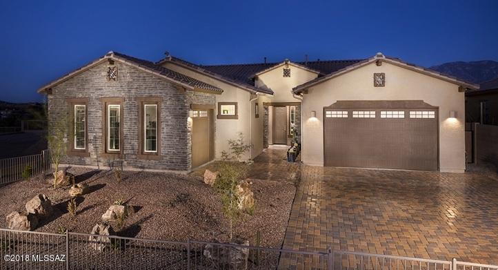 This gorgeous Revelation MODEL is now for sale, able to close the end of August! Home features our ''Next Gen'' home w/in a home w/attached separate living quarters! Main living area has 3 bedrooms and 2.5 baths, while the Guest space offers 1 BR, 1 bath, LR & kitchenette! The main area boasts of a large great room and gourmet kitchen w/large island dining area looking out to pool & Mountains! Granite c-tops in kitchens, w/quartz  in all baths! Homesite backs to common space & east Catalina Mountain view! Upgrades are many: Super Kitchen w/Monogram appli, Upgrd Tile everywhere, FP, automated window cvrngs in Great rm & MBR & wood shutters, Spa shwr, 2 tone paint, 12' SGD, Upper Deck, LED lights & more! Public report available on AZDRE website.Call ahead 1 hr:800-864-1055 for appt.