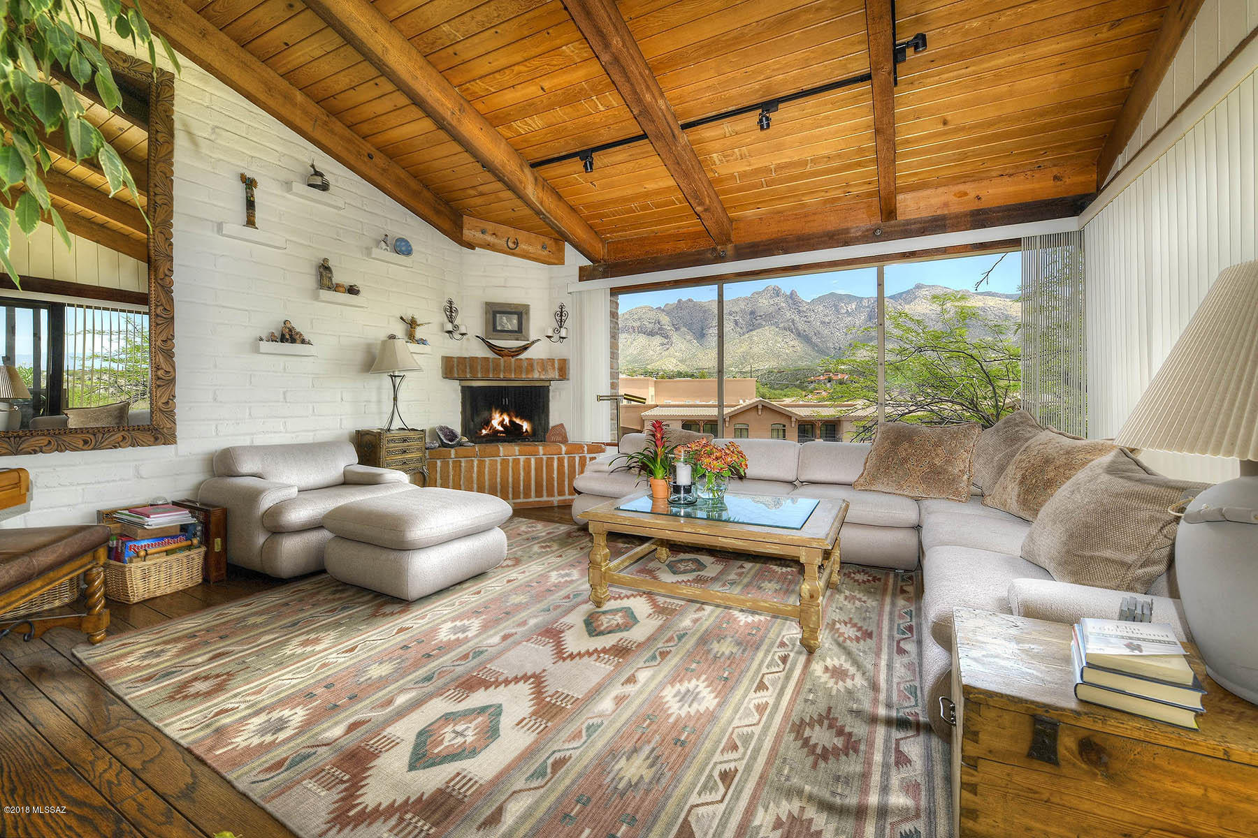 Timeless mortar-washed adobe classic with sensational mountain views. Vaulted wood beamed ceiling, exposed interior adobe walls, select hardwood and saltillo floors, masonry fireplace with gas log-lighter, picture windows in every room to capture the beautiful vistas, charming courtyard entry with many patios to capture the true essence of the Tucson Lifestyle, heated community pool, water purification, convenient walking to Starbucks, Flemings, Tavolino, Vivace restaurants and La Encantada shopping. A secluded hidden gem community in the heart of the central foothills. Main living on first level. Rarely does a property in this enclave of 16 residences become available. For those who seek a home with character and charm, the journey ends here.