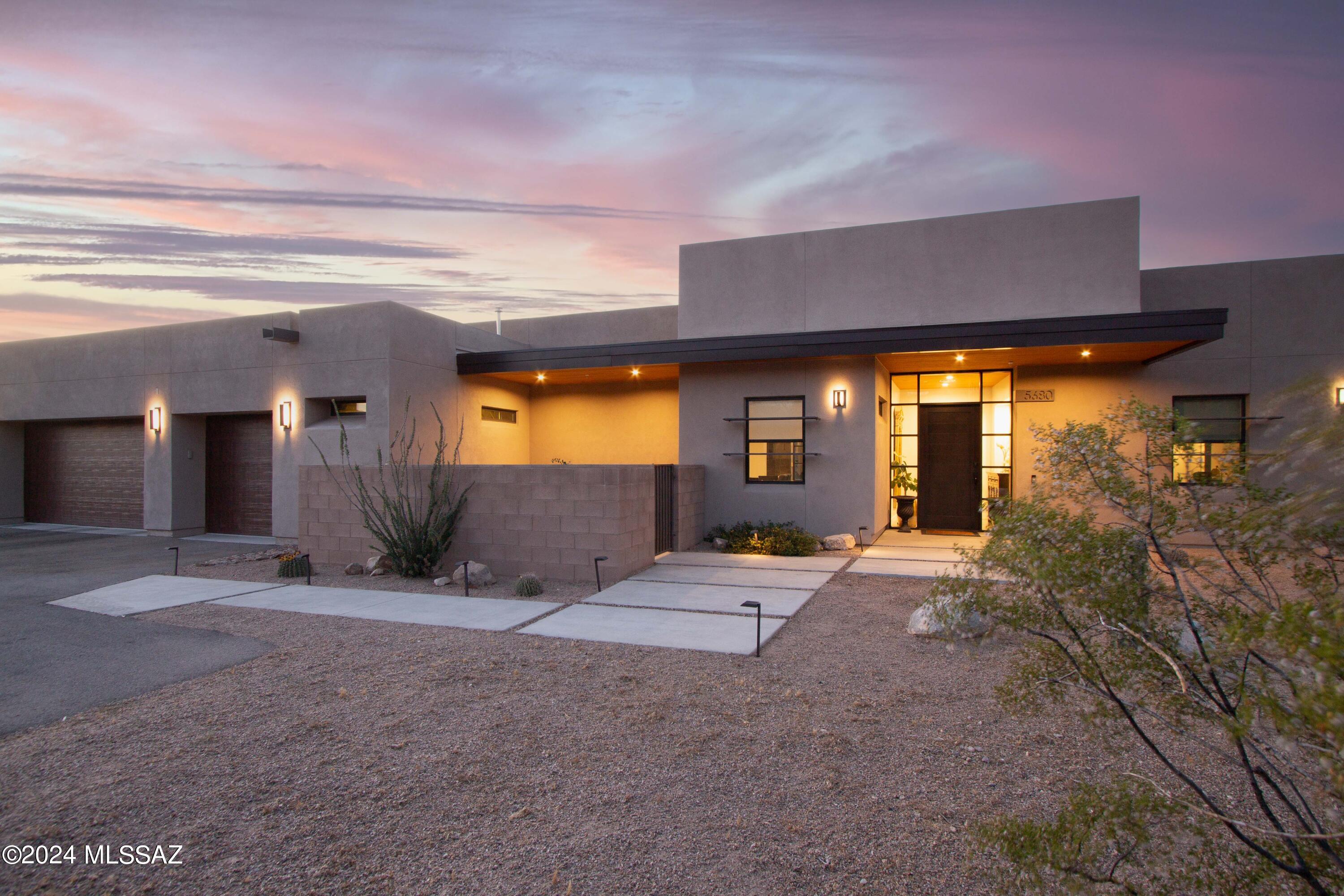 Discover your dream home in this stunning custom, architect-designed home. Located within Tucson Mountain Reserve, this property offers mountain, city, and sunrise views. The focal point of the living space is the sleek, modern gas fireplace creating an ideal space for both relaxation & entertaining. Polished concrete floors add modern sophistication & the gourmet kitchen boasts top-of-the-line appliances, including a 36'' gas range top, plenty of storage with a hidden walk-in pantry, and a built-in beverage station. The primary bedroom suite is well appointed with built-in closet cabinetry & a spacious shower. The home was designed with 3 bedrooms + a den, with the flexibility to easily convert the den into a 4th bedroom. Need storage? Don't miss the extra deep & wide 3-car garage. This home is a true masterpiece.