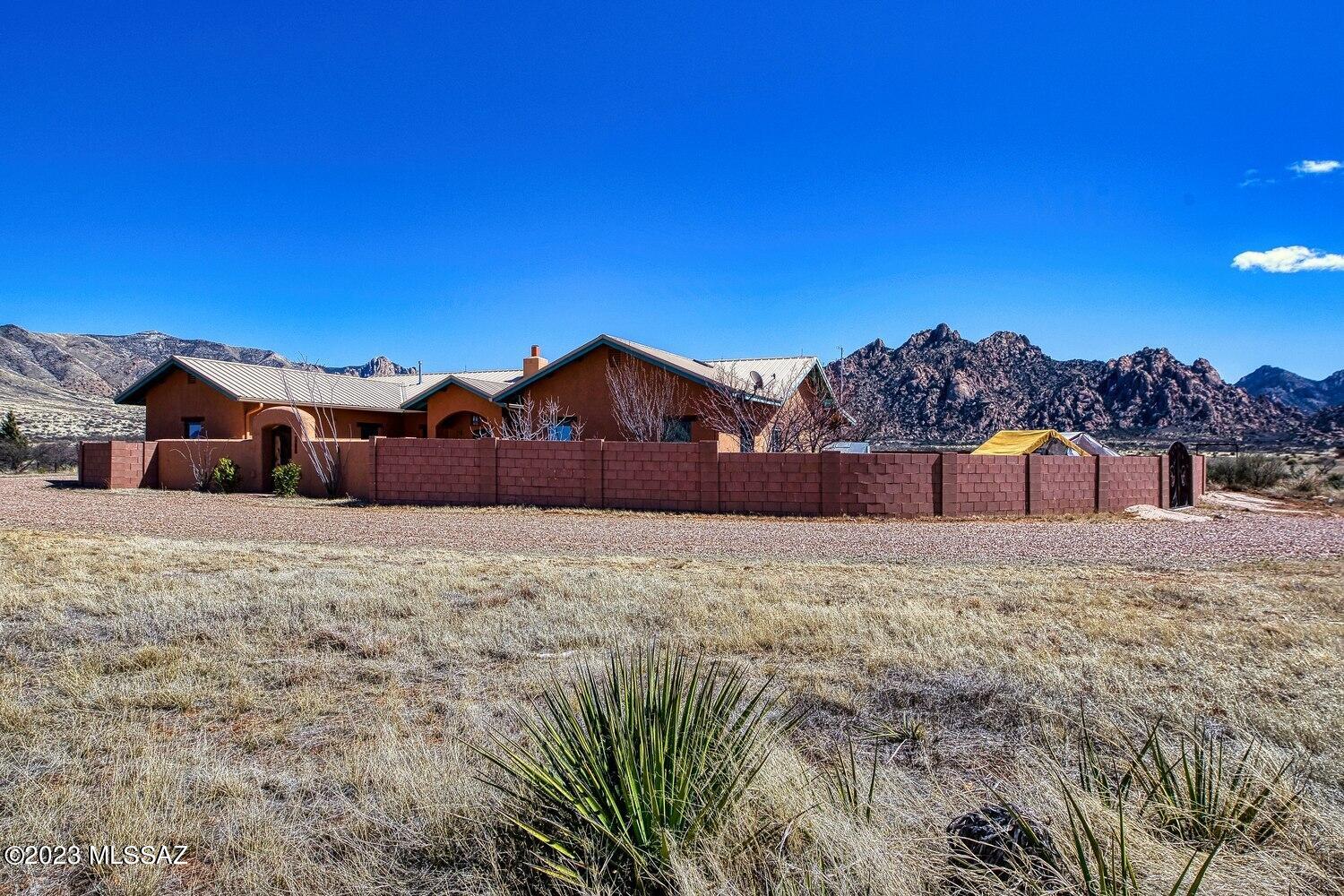 EXQUISITE, ELEGANT, EXCEPTIONAL.  Stunning Dragoon Mountain Ranch estate artfully designed by Benny Gonzales & laid out at the foot of the historic Dragoon Mountains for unparalleled, majestic views.  This publish-worth home has had the following enhancements:  5' high block wall surrounding the home, decorative courtyard gate, perimeter fencing, 3 snake-proof gates on backyard wall, new water pump & cabling to a depth of 950', 1600 gal water storage tank, prof graded & modified horseshoe driveway, AB base driveway material followed by Colorado Brown gravel, arbor installed, partitioned & insulated garage w/ mini split system for art studio, 2 new garage doors, new cell phone booster & new 2nd RV outlet w/ new 50 amp outlet for a total of 2 full hookup locations. More in ''SUPPLIMENT'' tab Main home has dual air conditioning with separate thermostats.  High end interior enhancements include: new granite countertops in kitchen, whole home interior paint and concrete floor refinishing. 1 BR, 1 BA adobe brick guest house with full kitchen including refrigerator.  3 BR, 3 BA in main home, 1 BR, 1 BA in guest home.  Luxury country living at it's finest!