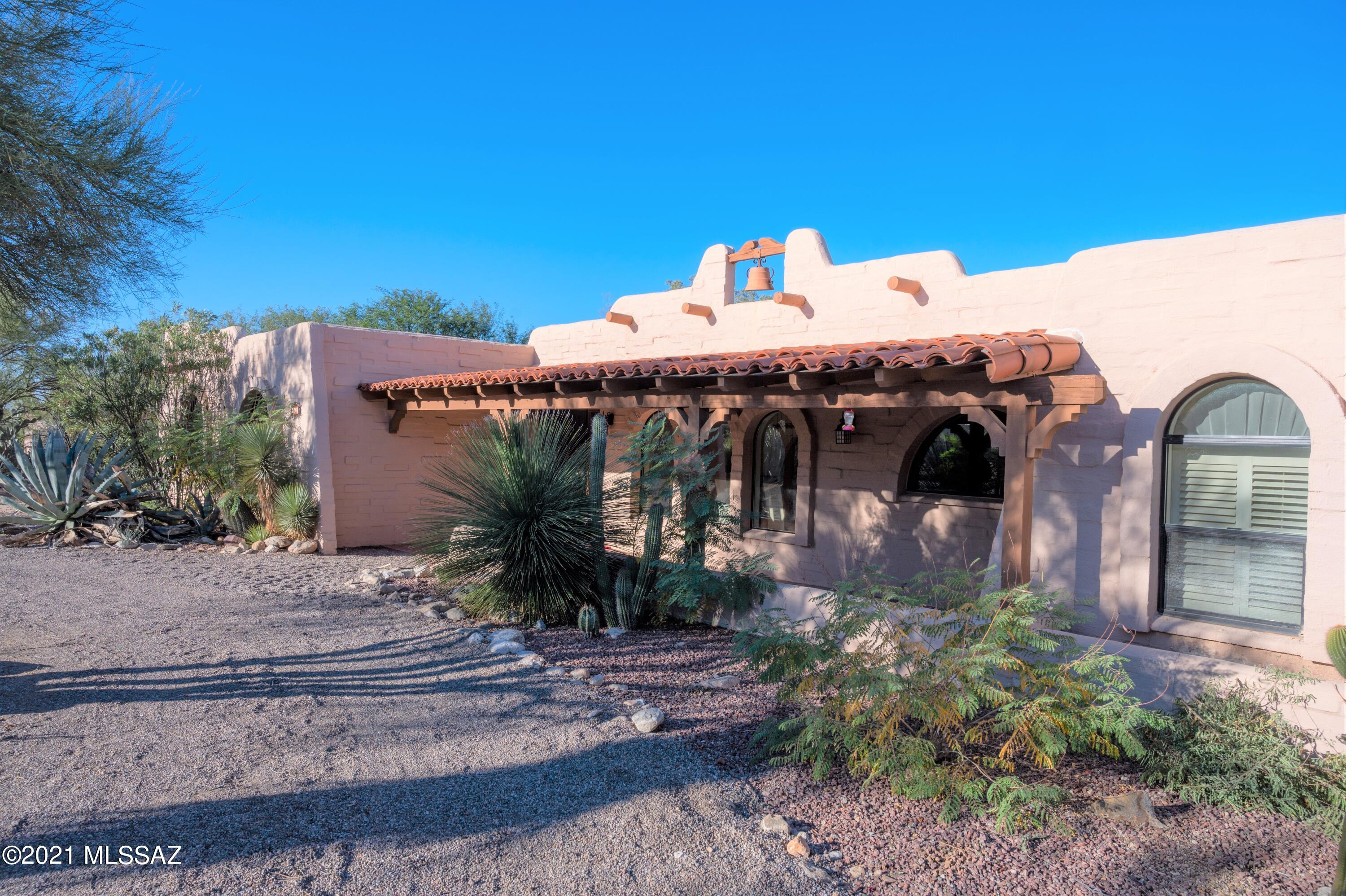 Classic old foothills southwestern 4 BR/3BA MAIN  HOUSE and SEPARATE 600SQFT 1 BR/1BA GUEST HOUSE. Circular driveway, huge front patio, mexican tile, spacious formal dining room, wood burning fireplace separates living room & family room. Updated kitchen has island & new stainless appliances.  On one side is the huge master suite w/a spacious sitting area/library w/built in bookcases & fireplace and also 2 large bedrooms/1 bath. There is another bedroom/bath on opposite side perfect for office or guestroom. Enjoy the expanded 363 sq.ft. Arizona Rm (not included in square footage) w/lots of closets & storage space, windows galore & sliders to covered patio, private outdoor living area & solar heated pool w/mountain views. Huge 2-car garage/storage/wkshp. Another Diamond in the Desert!