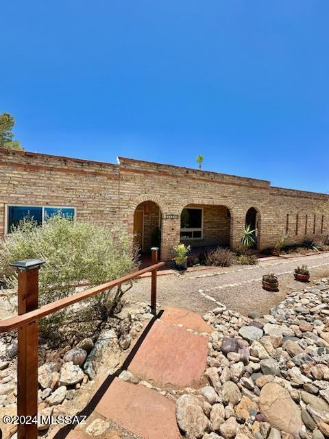 Seller will accept or counter offers between $8250,000-$850,000
 on this RARE FIND - A One of a kind custom, Old Tucson-style Ranch home with Horse Facilities on 5.15 Acres. Views of the Rincon Mountains & City Lights. Rustic feel w/open beams & woodwork throughout home. All tile floors, 2 fireplaces & Lg kitchen. Rare burnt adobe, solid masonry construction. This home exudes casual western living & quality workmanship. Open entertaining w/spacious family room, covered back patio. Pool-size Lot, Waterfall Pond in backyard; Permitted breezeway Barn has 4 stalls, tack room, hay storage, covered trailer parking (the 3rd Carport), & Wash Rack. Large arena 100' x 200'. ideal horse property! RIDE-OFF on neighborhood dirt roads! *View Barn Photos*