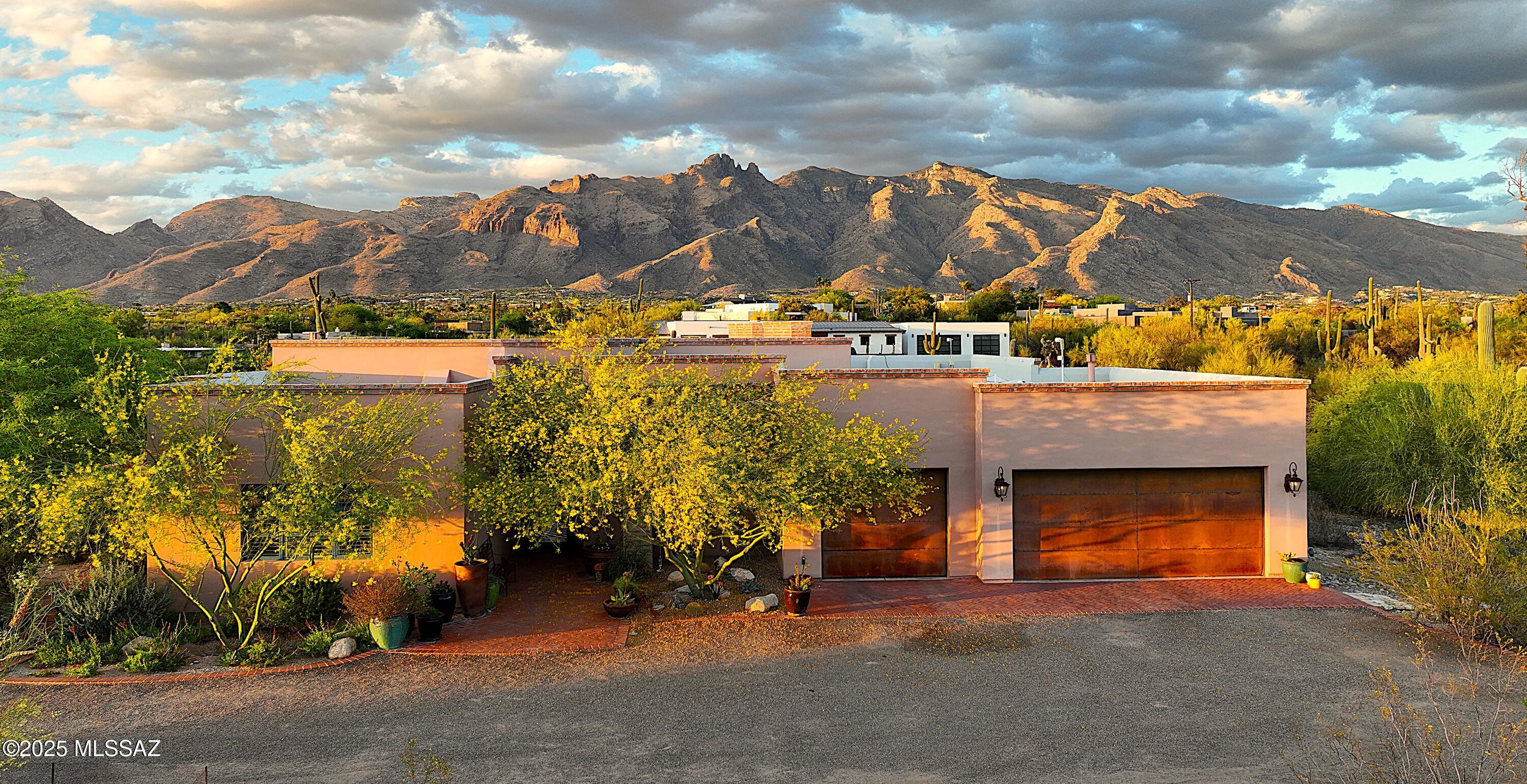 Stunning Catalina Mountain views & timeless territorial charm sits on an elevated 1.75-acre Foothills lot w/sky high beamed ceilings.  Luxurious custom home has outdoor living w/generous covered patios, an outdoor kitchen, fireplace, Talavera fountain & extended brick pavers. Beautifully appointed interior features saltillo tile, alder cabinets as well as 8' alder doors, a Sonos sound system, spacious greatroom with dramatic fireplace and wall of steel casement windows framing the mountains. Gourmet kitchen offers Thermador SS appliances, a 90-bottle wine fridge, mesquite island & large walk-in pantry. Primary includes dual vanities, walk-in shower and huge closet. Enormous 3-car garage w/bonus storage room and unbeatable Foothills location complete this exceptional home.