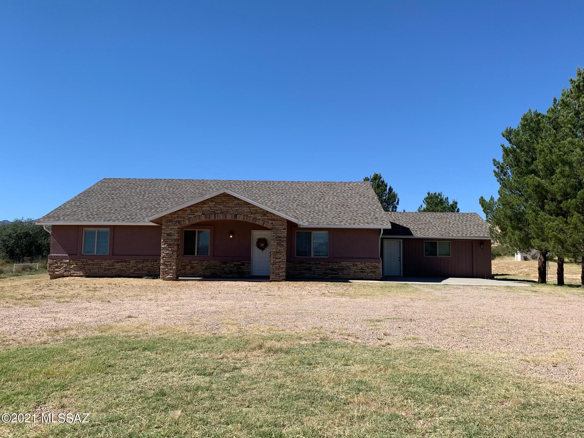 Gorgeous, well-kept home on 4 acres of horse property with stunning mountain views.   Great Room Concept w/ Living Room and Dining Area off Kitchen. Hickory cabinets and the vaulted ceilings add to this homes charm.   The French doors off the dining area open to a large covered patio for outdoor living.  Bedrooms are large.   Huge rec room with painted and scored concrete floors.  Gutters and sidewalks are nice upgrades.  Large concrete pad for parking.    Mature trees line the road, nice entrance, some pipe fencing.  You will love the view out this front porch!   NO HOA .  Rec room could easily be converted to a garage.   1/2 well share.