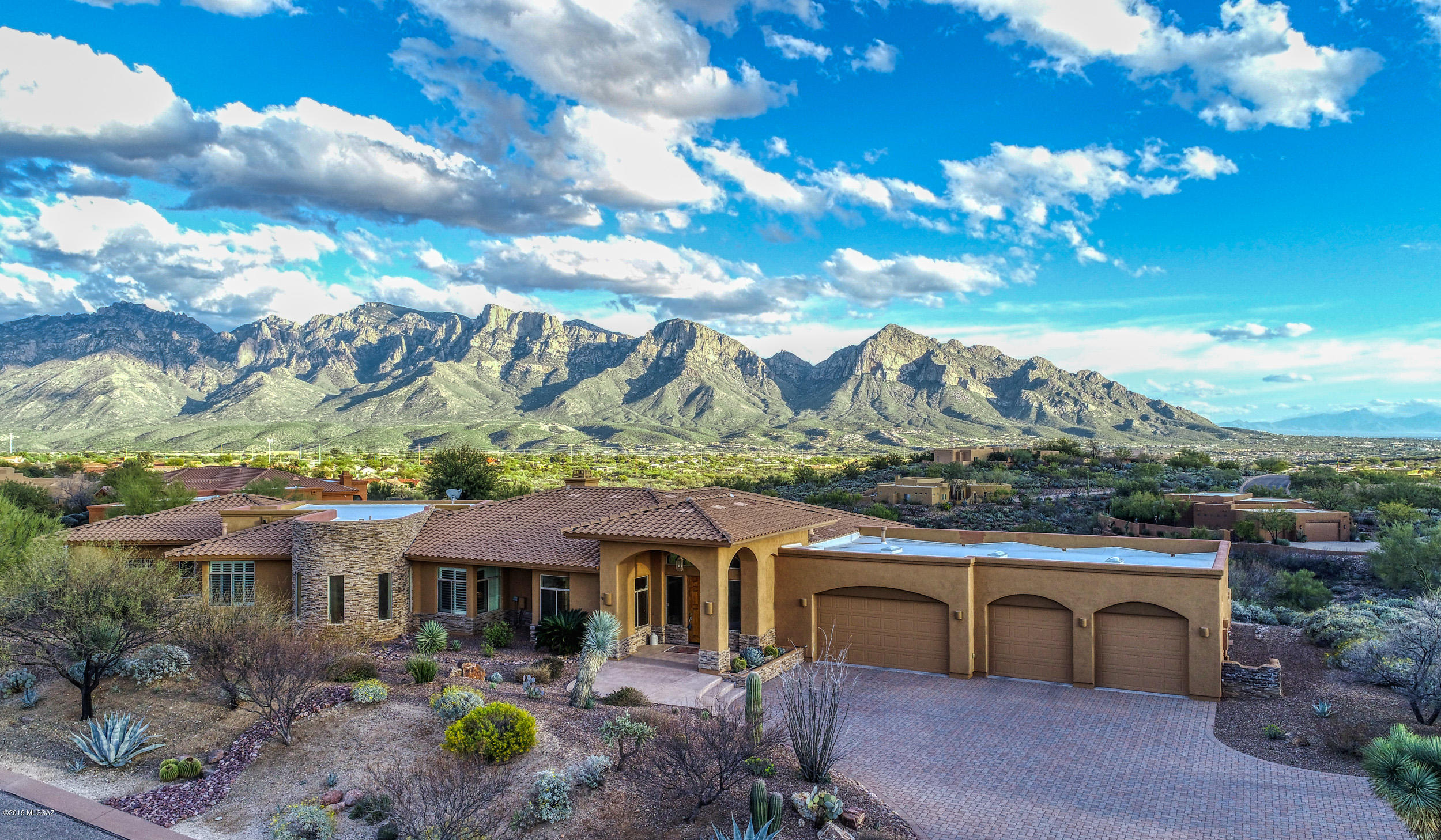 Custom Built-Absolute BEST VIEWS in town!! W/unobstructed panoramic vistas, the Catalina Mtns are literally in YOUR backyard!! Perched on a cul-de-sac lot, you have the privacy & freedom to choose to swim in the pool w/waterfalls, relax in the spa, warm up by the fire pit, grill your favorite meal at the covered granite BBQ dining area all while gazing at the downtown lights! Once in the interior kitchen, you can prepare gourmet meals for family or friends. W/expansive granite center island & wet bar, high end stainless steel appliances, wine chiller, unique wood beam ceiling in formal dining & spacious great room &/fireplace, your guests will truly be impressed. Master suite features seating area, fireplace & HUGE walk-in closet! And for the car enthusiasts, there's even a 4-car garage!!