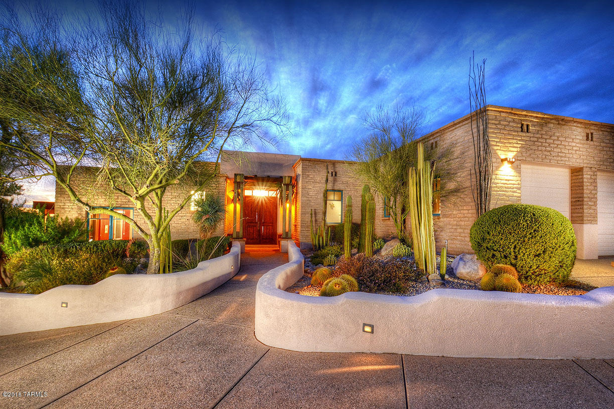 La Paloma at its finest. This territorial style mud adobe home is one of a kind. The grand foyer opens up to a large great room w/fireplace, wet bar & many views. Spacious kitchen has hand painted tiles, large island with cook-top & cozy beehive fireplace. Entertainer's dining room w/views of the beautiful landscaped yard & pool. Home features Lutron lighting system and unique metal art throughout. Master has his & her bath combo w/common walk-in shower, and two closets. Generous guest bedrooms are en-suite. Den w/mesquite floors can double as an extra bedroom. Guests will love the 886 sq ft well appointed separate house w/mini kitchen & mtn. views. Enjoy Tucson's sunsets from the back patio with fireplace, overlooking sparkling pool. Bonus 4 car garage w/extra space and storage.