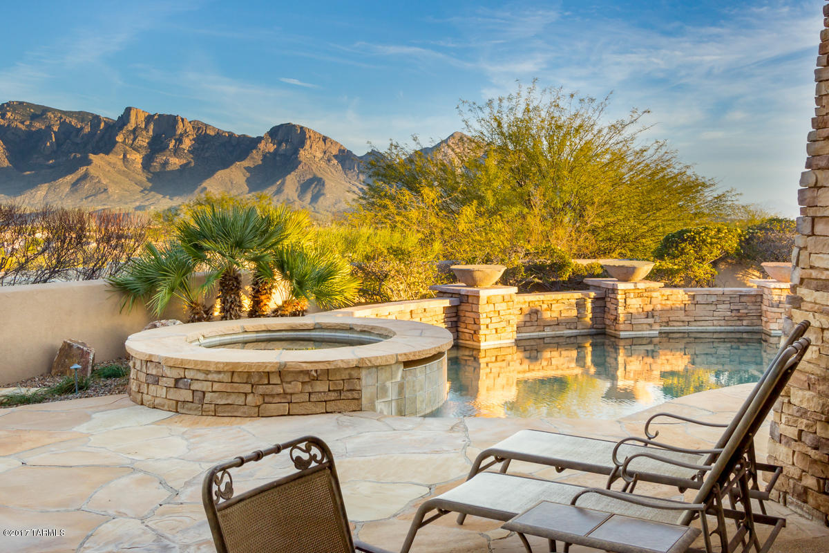 Oro Valley - Majestic ridge-top setting on private cul-de-sac lot w/unobstructed Catalina Mountain panoramic views. 10ft wrought iron/glass door greets you while views pour in from wall of windows. 4BR/3½ bath 3,209sf home + 856sf 1BR/1BA guest house w/same amazing views!! Custom home w/stone columns, stacked stone fireplace & pebble-tec pool, spa w/water features. Open great room floor plan w/gourmet kitchen w/Custom Hickory cabinets, island, beautiful slab granite counters, pantry, casual dining area & stainless appliances. Formal dining area w/coffered ceiling. Split floor plan offers an extraordinary master suite w/walk-in closet, garden tub & separate shower. Guest house, plumbed for kitchen, has scored concrete floors & travertine walk-in shower. 3+ car garage w/storage.