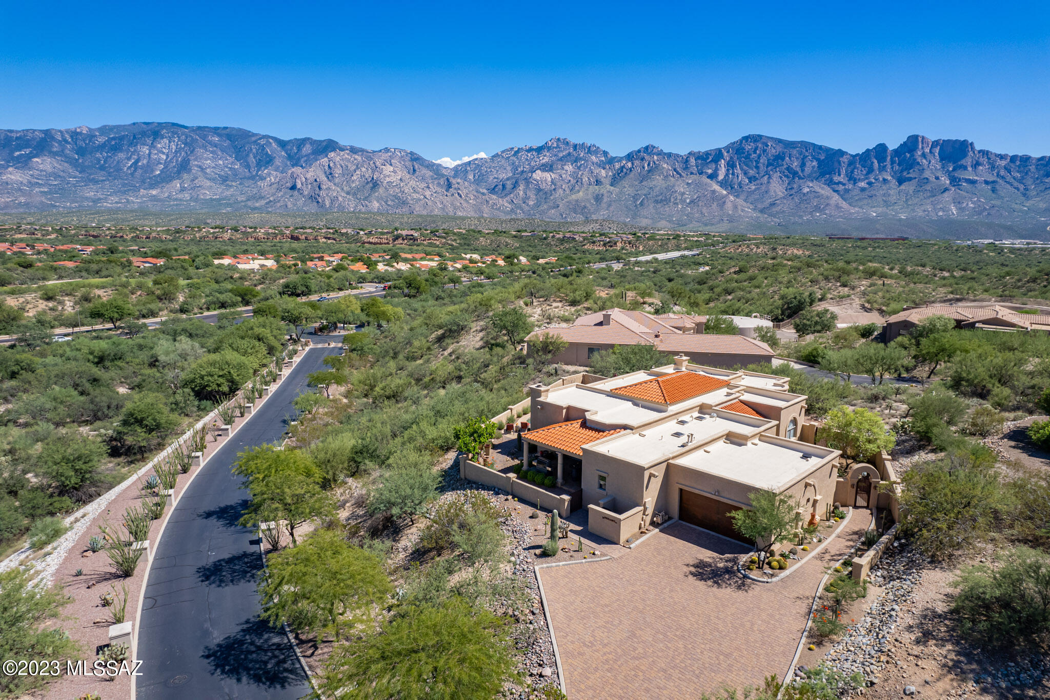 A gorgeous abode in elegant, quiet and gated Estates at High Mesa, a high-end lovely community in Oro Valley, is now available for discerning buyers. Stunning, sweeping views of the Catalina Mountain Range and nearby golf course are visual treats from nearly every window in this beautiful and comfortable home. Much has been subtly upgraded and improved by the current owner. A delightfully landscaped walkway and courtyard perfect for morning coffee welcomes visitors, who enter into a wide entryway showcasing enjoyable views of the Mountains over the comfortable great room and lovely pool in the rear yard. This living area features coffered ceilings, a dining area, a handsome built-in buffet with two wine refrigerators (Not quitters, these homeowners!) and equally handsome built-in bookshelves. Lots of wall space for your art and photos.  Glass sliders lead to the enjoyable outdoor space, compact but with plenty of room for a graceful pool and spa and covered terrace just right for relaxing and gracious entertaining. 
The kitchen area is a chef's dream, with gorgeous thick bull-nosed granite counters providing excellent workspace. Stainless high-end appliances, excellent cabinet space with pull-outs for lower shelves, plenty of cabinetry and a nearby pantry are all available. An adjacent cozy breakfast nook enjoying desert views opens to a charming side patio with a bar-b-que. This patio is also accessible from the guest room on the south side of the home. A comfortable family room has a wonderful fireplace, more stunning views, niches for TV and art/books, and a sliding door to the main back terrace. The guest bedroom nearby is generous and welcoming, with an ensuite full bath, a walk-in closet with built-ins, and access to the breakfast patio. Nearby is another bedroom currently used as a convenient office, with an adjacent full bath. The laundry room provides cabinets and a sink along with a stainless washer/dryer and pantry space.
On the north side of the home is another office with a walk-in closet and a nearby full bath and the fabulous primary bedroom, a wonderful retreat. It's large, with yet more stunning views, a  coffered ceiling, a door to the primary outdoor terrace, and a cozy seating area. The beautifully designed primary bath enjoys two back-to-back elegant lavatory spaces, a separate WC, a hidden-away generous walk-in shower and nearby heated towel rack, and a Jacuzzi tub set in a beautiful stone surround, and a walk-in closet. Another closet is nearby with excellent built-in features. The two-car garage has built-in storage space that is very handy and accessible. This is a welcoming, sophisticated and comfortable home that should bring its new owners much happiness and enjoyment. You are invited to call for your private showing.