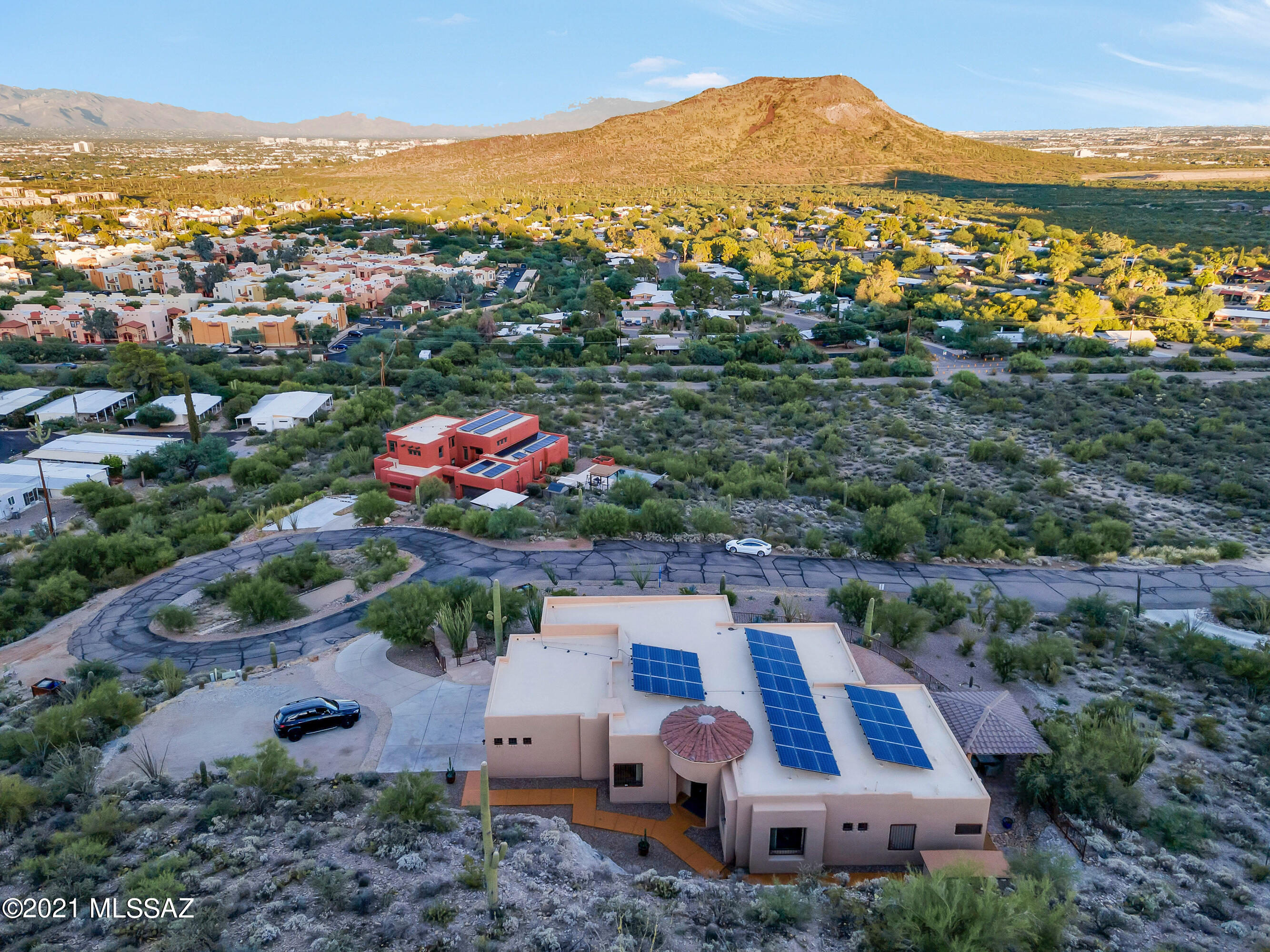Welcome to a custom home on Tucson's vibrant West Side, in a very private small gated community with stunning vistas of Tucson and its surrounding mountain ranges.  Built by the owners with great attention to detail and utilizing high-end materials and finishes, and well-located with quick access to downtown Tucson, Pima Community College, The University of AZ and the heart of Tucson's medical community, and Caterpillar's downtown offices, this stunning home will be perfect for professors, doctors, lawyers, engineers and other professionals, or anyone seeking a peaceful and handsome residence near Tucson's best downtown amenities and cultural opportunities. The home features elegant iron and glass exterior doors with screened side openings to let in a cross-breeze in our delightful winters, custom created in Mexico. Upon entry through these doors,  look across the spacious great room and be "WOWED" by the "Million Dollar" sweeping views of the Catalinas and Rincons mountain ranges to the rear of the home. Step outside to the spacious elegantly pavered terrace for more vistas, including over to the Tortolita Mountains. Imagine 4th of July with views of fireworks across the Tucson Valley! Step into the custom gazebo with granite bar, refrigerator, accent lighting and room for eight to wine and dine alfresco.  Returning inside, notice the intimately sized dining room with an elegant iron chandelier. The spacious kitchen is a chef's dream, with long executive height counters of stunning Indian Parana granite providing copious workspaces. Appliances are stainless by Kenmore, including double wall ovens. A comfortable breakfast space is adjacent. All cabinetry is solid  wood, with pull-outs in lower cabinets and soft-close features on all drawers. Nearby is a powder room with a charming antique-style sink stand topped with black marble. 
The oversized Owner's Suite enjoys stunning views and another double iron & glass door to the terrace. With a large walk-in closet, the spacious Owner's Bath features a large oval Jacuzzi tub, walk-in shower with two showerheads, long cultured marble counter with double sinks topped by a handsome iron-framed mirror, and a separate toilet room. Two guest bedrooms are located on the opposite side of the home, with another full bath nearby. The laundry room enjoys more cherry cabinets, an attractive sink and a drying area. The generously sized three-car garage has epoxy floors, storage cabinetry and an air-conditioned "Bonus" room with more excellent views, perfect for a craft space, yoga/workout space, or additional office space that can easily be connected to the main house if desired. 
The entire home has 10' ceilings and 8' doors and executive-height toilets. With the leased solar panels, electric costs average $20/month with a $120/month lease payment. It is in a small gated community of only 14 lots, of which seven have homes, There is ample distance between homes and a friendly atmosphere between neighbors. It's a quiet, peaceful community with lots of great school options nearby. You are invited to call for a viewing appointment today.