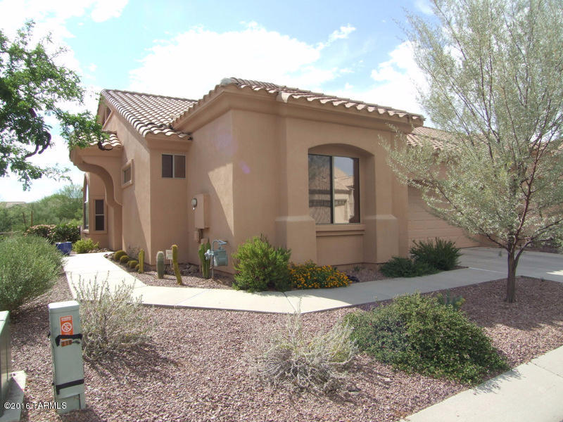 Just listed! Premium lot backing to desert common area in the beautiful and immaculate gated retirement community of Vistoso Village in Oro Valley. Very private and quiet location.  Popular floor plan... two bedroom, plus den (optional 3rd bedroom), great-room with fireplace, spacious kitchen with maple cabinets and breakfast bar, 3 bay windows, private covered patio, 2 car garage with storage cabinets.  Refrigerator, washer and dryer included. Enjoy care free living, the HOA covers water/sewer, garbage collection, basic cable TV, outside pest control, landscaping, exterior painting and roof maintenance, gate and private streets.  Amenities include club house, two pools, gym, and library.  Immaculate condition with neutral color palette.
