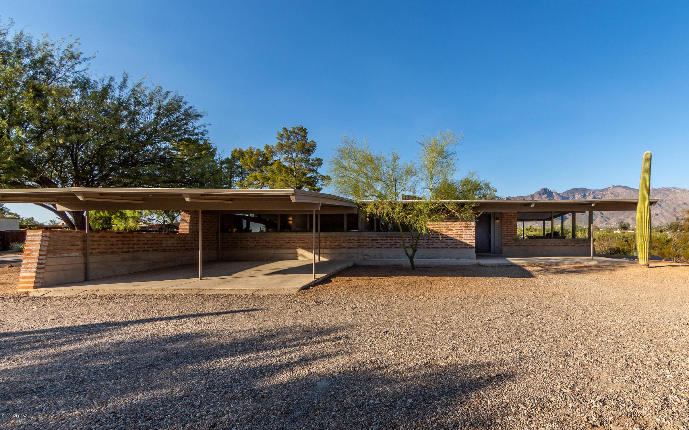 Beautifully restored midcentury modern home built by noted Tucson builder Tom Gist, situated high on a hill with panoramic mountain and city views. This beautiful burnt adobe home features custom built rift-cut white oak cabinetry and matte finished quartz counters in the kitchen and main bath. The kitchen is complete with gourmet appliances including a cabinetry paneled built-in GE Monogram refrigerator, a cabinetry paneled Asko dishwasher, Dacor gas cooktop and Dacor convection oven. Take in the views from the living room through the expansive windows and the serene courtyard. The owner's suite has patio access and 2 closets. This is a special home, not to be missed.