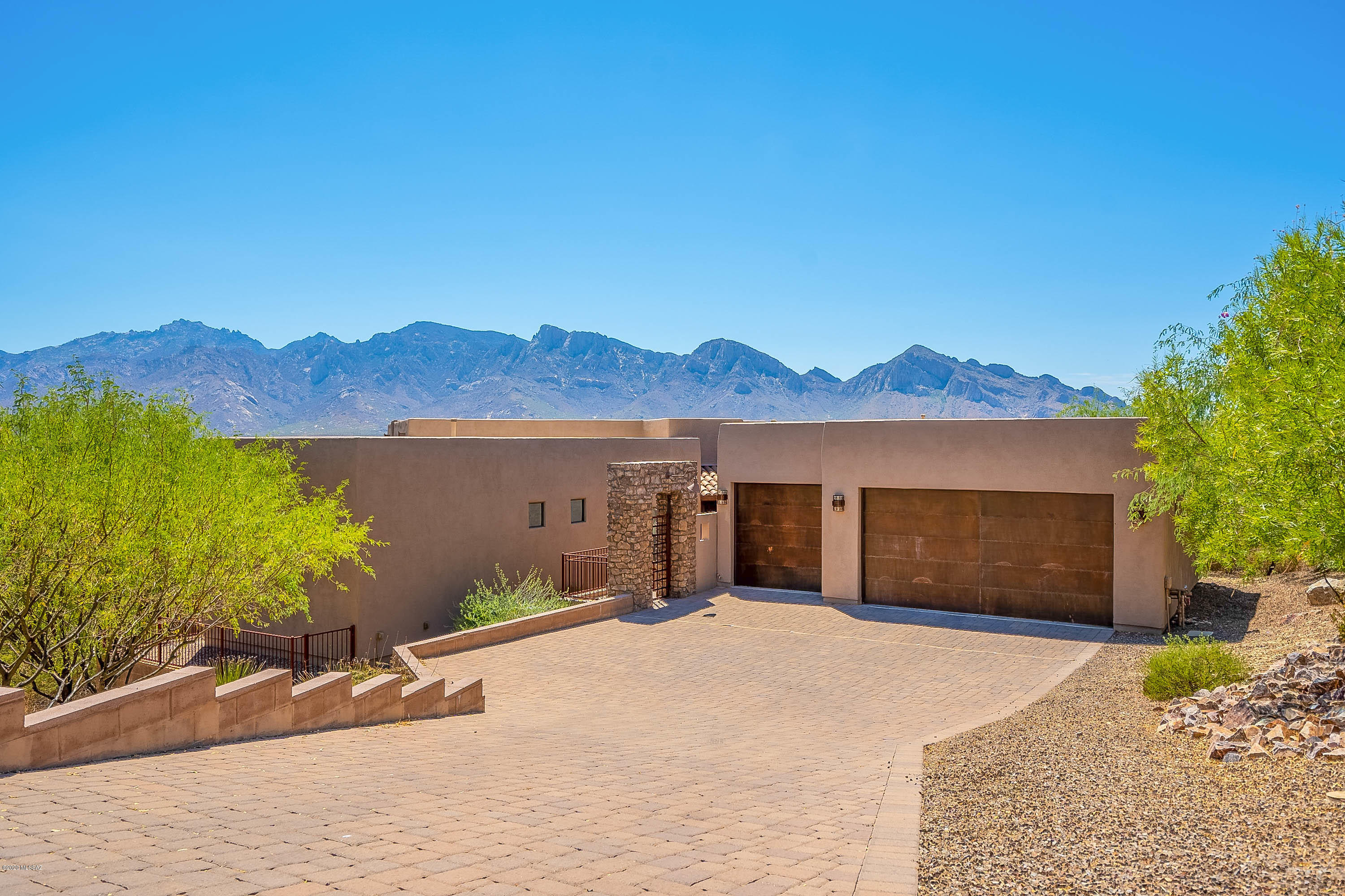 Spectacular mountain and city views are front and center in this custom 1+ acre retreat. The Great Room features a Window Wall which allows you and your guests to seamlessly move to the large covered patio. Swim laps in the Pebble-Tec Pool or just relax in the lagoon area and enjoy unimpeded Catalina views. The floors are premium porcelain tile and all cabinetry is made from premium cherry wood. The kitchen boasts stainless steel appliances including a wolf cooktop. A guest suite, an oversized garage (1000+ sq ft), and low maintenance landscaping professionally designed by award-winning designer Shelly Ann Abbott are some of the other high-end features of the home. This owner/agent home also has an astronomical observatory to take advantage Oro Valley's famous dark skies.