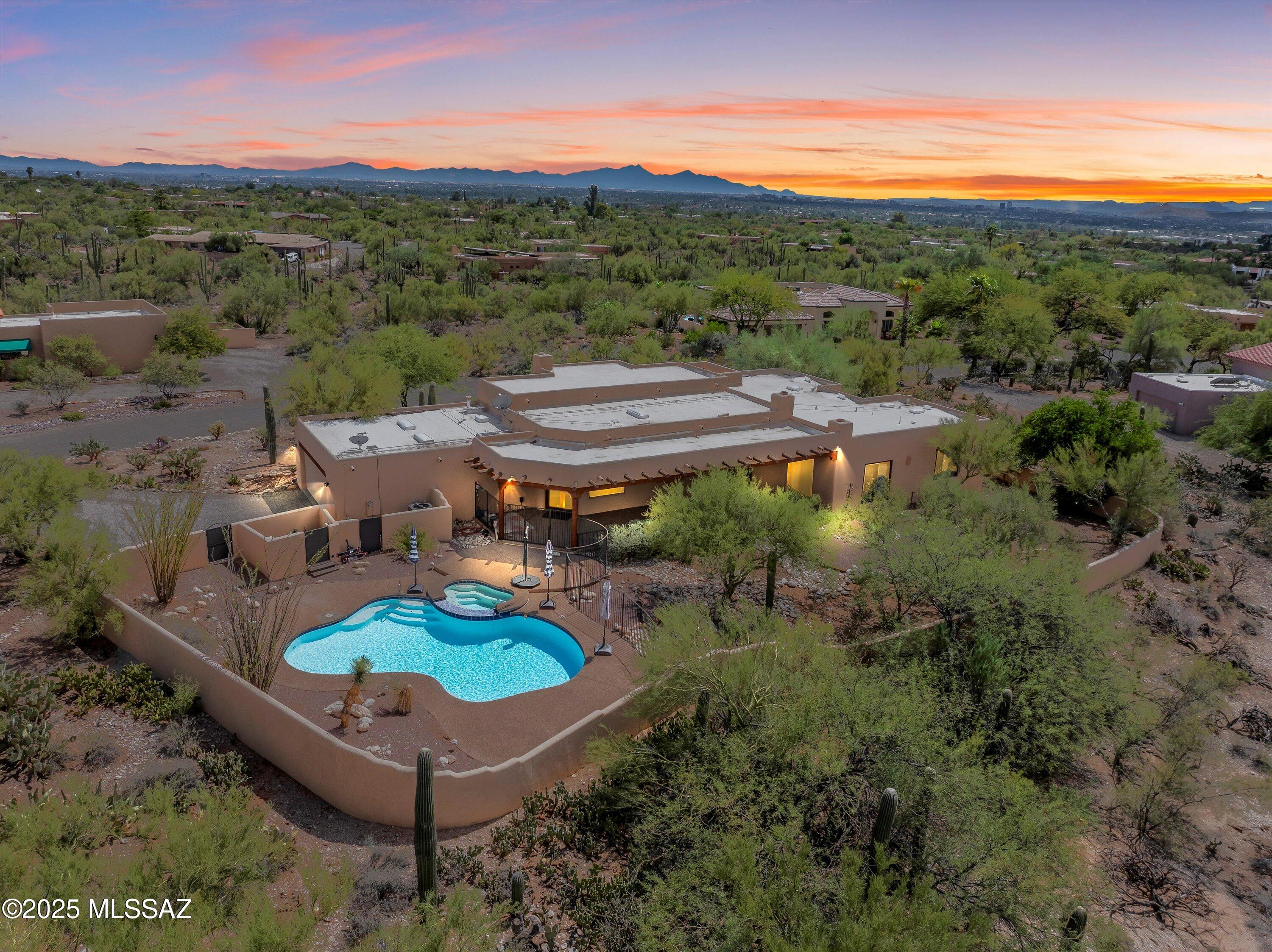 Step into the essence of Arizona living with this stunning 3,040 square foot single-story Santa Fe estate, where breathtaking Catalina Foothills mountain views and a sparkling pool create an immediate sense of luxury and tranquility. Perfectly positioned on an oversized lot in the prestigious Shadow Hills community, this exceptional property welcomes you with the authentic spirit of the Southwest and timeless desert-inspired elegance from the moment you arrive.
This exceptional four-bedroom, three-bathroom home captivates with its authentic character and undeniable charm, featuring soaring ceilings adorned with plank and viga beams and rough-hewn accents throughout. The warm saltillo tile flooring creates a seamless flow between the thoughtfully designed living spaces, while three kiva fireplaces provide cozy gathering spots and showcase the home's authentic Santa Fe heritage.
Natural light floods the interior showcasing breathtaking Catalina Foothills vistas and lush desert vegetation while maintaining the home's light and airy atmosphere. The gourmet U-shaped kitchen with expansive center island is a chef's dream, featuring gas cooking, stunning mosaic tile backsplash, quartz countertops, stainless steel appliances, beverage fridge, a convenient breakfast bar, and abundant storage solutions for the most discerning homeowner. Architectural details abound with beamed and vega-accented entries, graceful arched niches, custom display nooks, and traditional built-in seating that enhance the home's distinctive ambiance. Authentic corbels support the magnificent beam work, while hand-carved details throughout showcase the meticulous craftsmanship that defines true Santa Fe architecture. The layout flows seamlessly between multiple living spaces - a spacious dining room ideal for gatherings and celebrations, an inviting living room, and an open family room that connects to the kitchen. The sunny breakfast nook lets you start your day watching the desert come alive. All spaces flow beautifully to the outdoor areas, perfect for relaxed desert living.
The primary suite offers a private retreat with generous proportions, dual walk-in closets, and an opulent bathroom featuring custom tile countertops with decorative accents, double vanity sinks, and a dedicated vanity area. The spa-like soaking tub is surrounded by exquisite custom tilework and features a built-in niche, while the spacious walk-in shower completes this sanctuary. Additional bathrooms showcase the home's authentic Santa Fe character with handcrafted tile surrounds, and distinctive Santa Fe design elements including custom mirrors and decorative accents. The versatile fourth bedroom offers flexibility as a home office or workspace, complete with built-in cabinetry and nature views from the desk area.
The true centerpiece of this remarkable property is the resort-style outdoor oasis, where a sparkling pool and spa take center stage against a backdrop of breathtaking mountain vistas. The private backyard paradise borders a natural wash, creating a serene sanctuary where native wildlife and birds provide daily entertainment while mature desert landscaping ensures complete privacy. The oversized covered porch and patio areas seamlessly extend the living space outdoors, perfect for year-round Arizona entertaining while soaking in those incredible mountain views.
Beyond the home's exceptional features, the Shadow Hills location offers an unparalleled lifestyle in the heart of Arizona's natural beauty. Nestled in the stunning Catalina Foothills, residents enjoy immediate access to world-class hiking and biking trails that wind through pristine desert landscapes and offer breathtaking mountain vistas. The area is renowned for its outdoor recreation opportunities, from challenging mountain bike paths to scenic walking trails that showcase the Southwest's unique flora and fauna. This coveted location combines the tranquility of desert living with convenient access to Tucson's finest dining, shopping, and cultural attractions, making it one of the area's most sought-after neighborhoods.
Don't miss this opportunity - contact Oliver Realty today to schedule your tour!