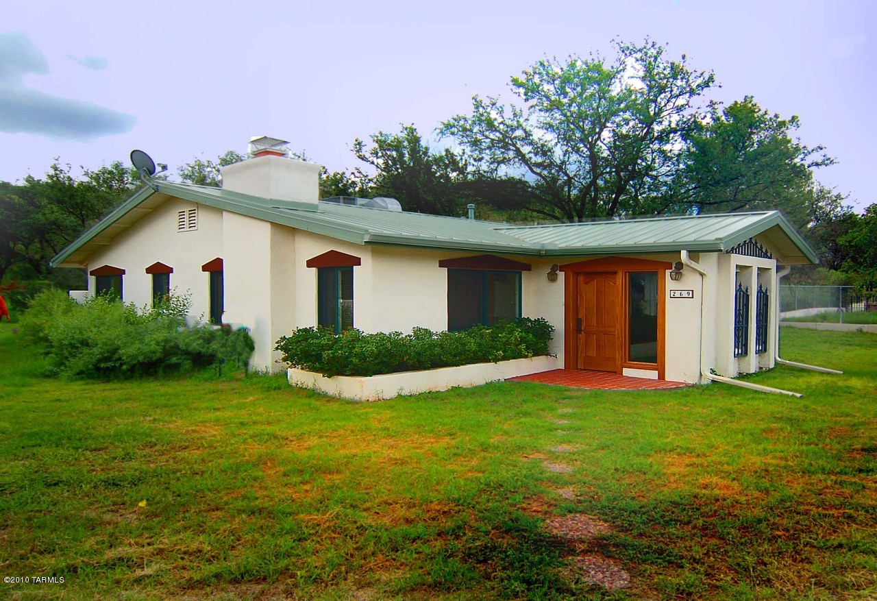 Regionally stylish 1,396sf 2BE, 2BA Patagonia cottage on .47ac. backing up to a peaceful hillside. The home is within Town boundaries & is a comfortable walking distance into the heart of the village. Property details include a 24gage steel roof & o/s gutters c.2001; a Private Well; a 6'x8' SUNSHINE Greenhouse + raised garden beds. There's an 8'x15' attached Arizona Room + 20'x20' Studio/Work Shop in the Garage w/2CP. The Flagstone patio at the rear enjoys a spacious private yard. The home's Formal Entry has an African Mahogany front door & the Greatroom features a stone/river rock fireplace at center; adjacent dining area & galley Kitchen. 6'X8' Laundry Rm off the AzRm; updated 2nd Bath & Ceramic Tile floors t/o. Milgard Dual Pane/Low E glass doors/windows w/fiberglass frames c. '03.
