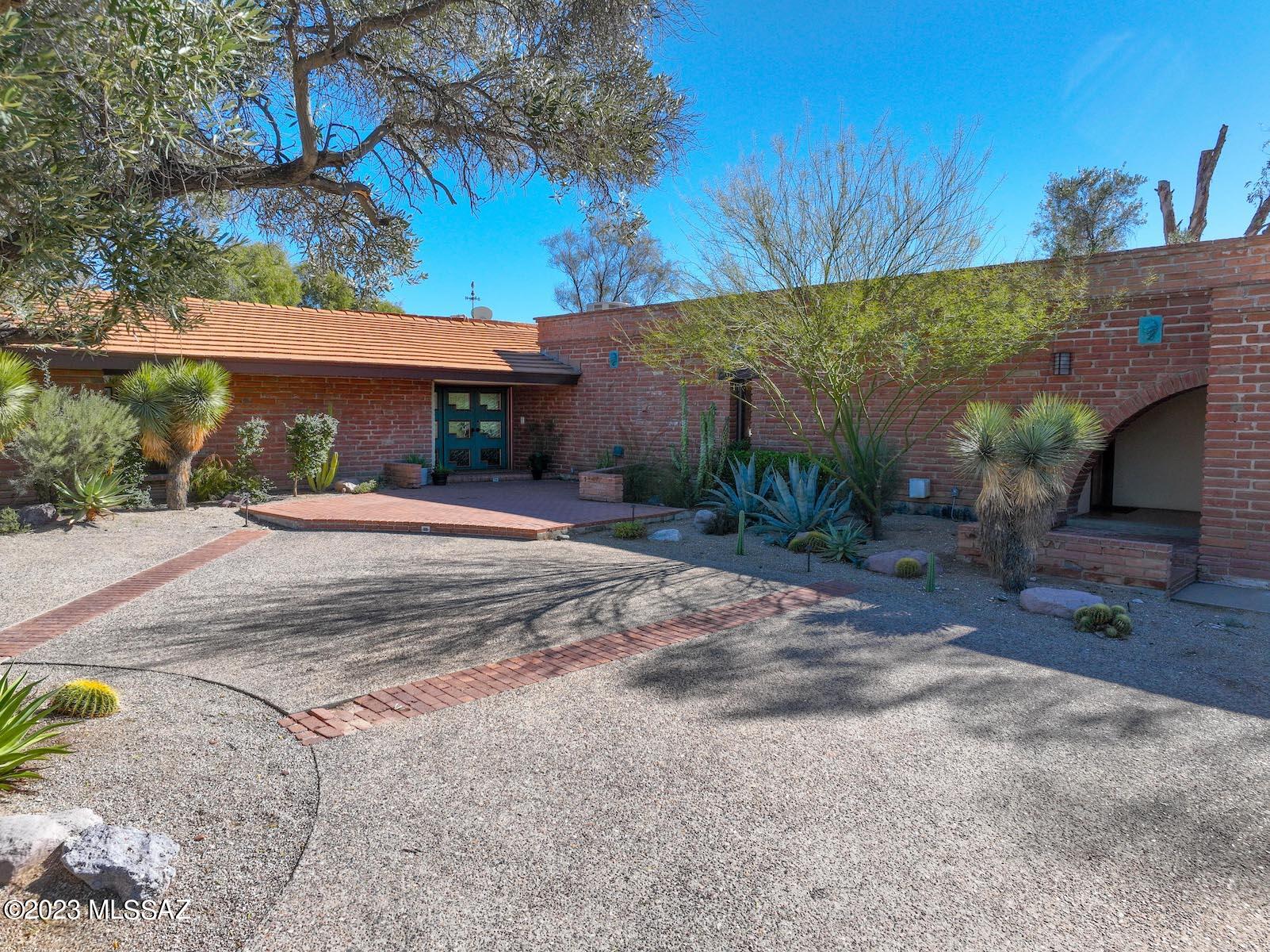Gorgeous 7.5 acre estate in the Lower Foothills. 6 bedroom, 5.5 bath, 5813sq' home designed by Nicholas Sakellar in 1952 reflects the indoor/outdoor aesthetic of Tucson with panoramic views of all local mountain ranges, the Sonoran desert, and a sweeping view of the urban corridor.

A true private oasis and an entertainer's dream: every room has access to the outdoors. 2 primary suites, separate guest quarters, comfortable light filled kitchen and a vast great room with stunning old growth Doug Fir beams from Oregon. This show-stopping space is outfitted with new modern sliders on both sides to highlight the views, centered by a graceful fire place and grounded with newly laid travertine tiles, while an atomic-aged mechanical rising bar winks to this magnificent home's mid-century heritage. 

The original primary suite faces the Catalinas and the immaculate 50's plaster pool with diving board and artist designed ramada. The owner's suite occupies the south wing of the house and faces east with fireplace, a large walk-in closet, 2 safes, a beautiful south facing glassed bathroom with spa, rain/steam shower, heated floors, and 2 vanities. The courtyard offers a covered and meditative water garden for reflection & frequent wildlife visitors, a short walk down the flagstone stairs you can settle into the hot tub under the stars.

Additional features include: 4 car spaces, 2 garages one with electric car charging station the other lower, copious storage, Klijian cherry cabinetry, basket weave adobe brick, built in liquor cabinet, new sunshades in sunroom, Japanese tile, Italian mosaic, cedar closet, workshop/2nd laundry room, upgraded electric panel ready for solar installation, garden plans, pruned bird of prey hunting tree, play structure and a fenced play court overlooking the arroyo.

List of numerous recent upgrades available.