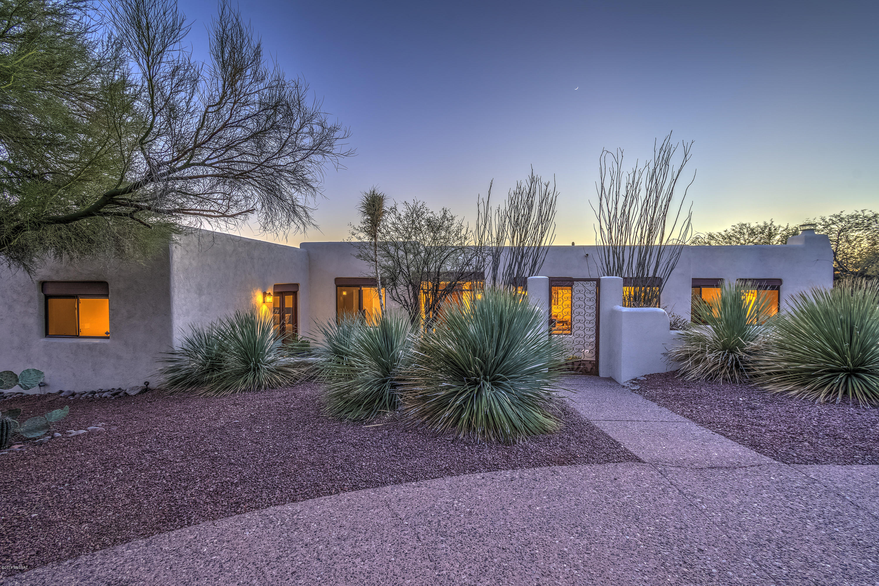 Beautifully warm and welcoming UPDATED custom Santa Fe situated on TWO ACRES, with TWO MASTER RETREATS and two additional bedrooms, in Catalina Foothills Estates 9, one of Tucson’s most popular foothills neighborhoods. Enter the beautifully gated front courtyard and find yourself in comfortable elegance, where high ceilings and expansive windows bring the beauty of the desert into the open living spaces of the home. Relax or entertain in the formal living and dining area, or in the family room with a corner kiva fireplace, wood flooring, and artfully crafted ceilings of rough hewn plank and hand peeled viga beams. Enjoy panoramic vistas of the Tucson Mountains and stunning sunsets in the wonderfully designed kitchen, featuring custom cabinetry, a spacious pantry, center island, and grani countertops. Each of the two master retreats with remodeled baths and exceptional closets, is sublime! The west retreat features full views of the Catalinas, a large seating area, separate reading corner, kiva fireplace, exquisite walk-in, travertine flooring, and french doors leading to the pool and spa. The east retreat is equally spacious, with a dressing room, and two sets of french doors, one leading to the front courtyard; the other to the beautiful park-like yard with full covered patio. Two additional bedrooms in the home each have walk in-closets and beautiful views. Add to this, gorgeous premium wood flooring, a most private pool and spa, exceptional well insulated 2x8 construction, a perfectly placed laundry, extended garage with high ceilings, a circular aggregate front driveway along with a private driveway (with extra parking for guests), north-south exposure, well maintained neighborhood roadways, fine southwestern detail throughout. Whether relaxing by two outdoor fireplaces, enjoying the pool and spa with sunset as the backdrop, entertaining in the gorgeous yard with forever-sweeping views of the Catalinas, or enjoying daily walks on the gently sloping winding roadways, you'll enjoy the best that Tucson has to offer! Venture out in the morning or evening to AJ's Fine Foods and upscale shopping at La Encantada Mall or some of Tucson's premier restaurants, each less than 5 minutes away. Weekend theatre, UofA games, downtown dining and events? All are less than 20 minutes away. You will love this beautifully designed home offering the serenity and beauty of true foothills living!