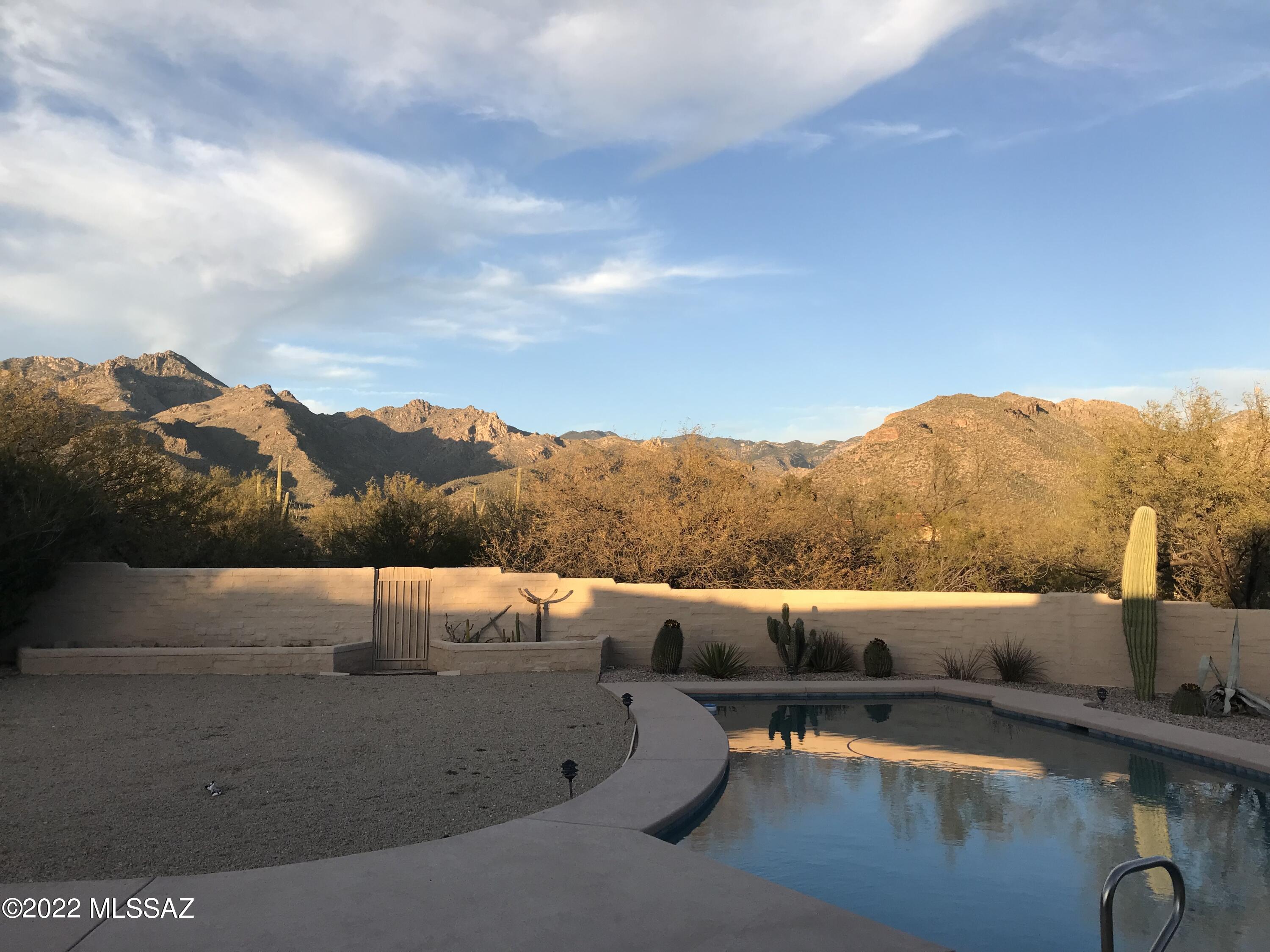 This beautifully maintained southwest home was built in 1979 on an exceptionally large and private lot with north facing unobstructed Catalina Mountain views making it one of the nicest lots in Sabino Town & Country Estates. Backing to Sabino Canyon Recreation Area means residents can enjoy Coronado National Forest in just a 2-3 minute walk via the private path at the north end of Stonehouse Pl. Walk a few minutes more and you're at the outstanding Catalina Foothills elementary and middle schools. Features include a 3 bedroom 2 bath split floor plan with a 3 car garage and 30' pebble tec pool. Take advantage of the fantastic useable backyard large enough for playground equipment, basketball, or volleyball/badminton. You'll find extra storage in the generous size 2 car garage with built-in cabinets, the multi-use heated and cooled storage/bonus room between the garages, and in the 3rd car garage you'll find ample workbench space.
Quality construction with 12" thick walls results in reasonable utility costs. Mostly desert landscape means low care is required for maintenance. Only the oleanders in the backyard require watering.    
Additional features include updated baths, an exposed wood beam ceiling, plantation shutters, Halcyon roll up sunshades, ceiling fans throughout, solar heat for the pool, kitchen solar tube light, and an updated kitchen with GE slate appliances.  Fire is included in taxes and HOA dues are very reasonable. The exterior was painted in 2022. As an extra bonus Pima county recently repaved the neighborhood roads in 2021 and 2022. Driveway replaced in 2020.