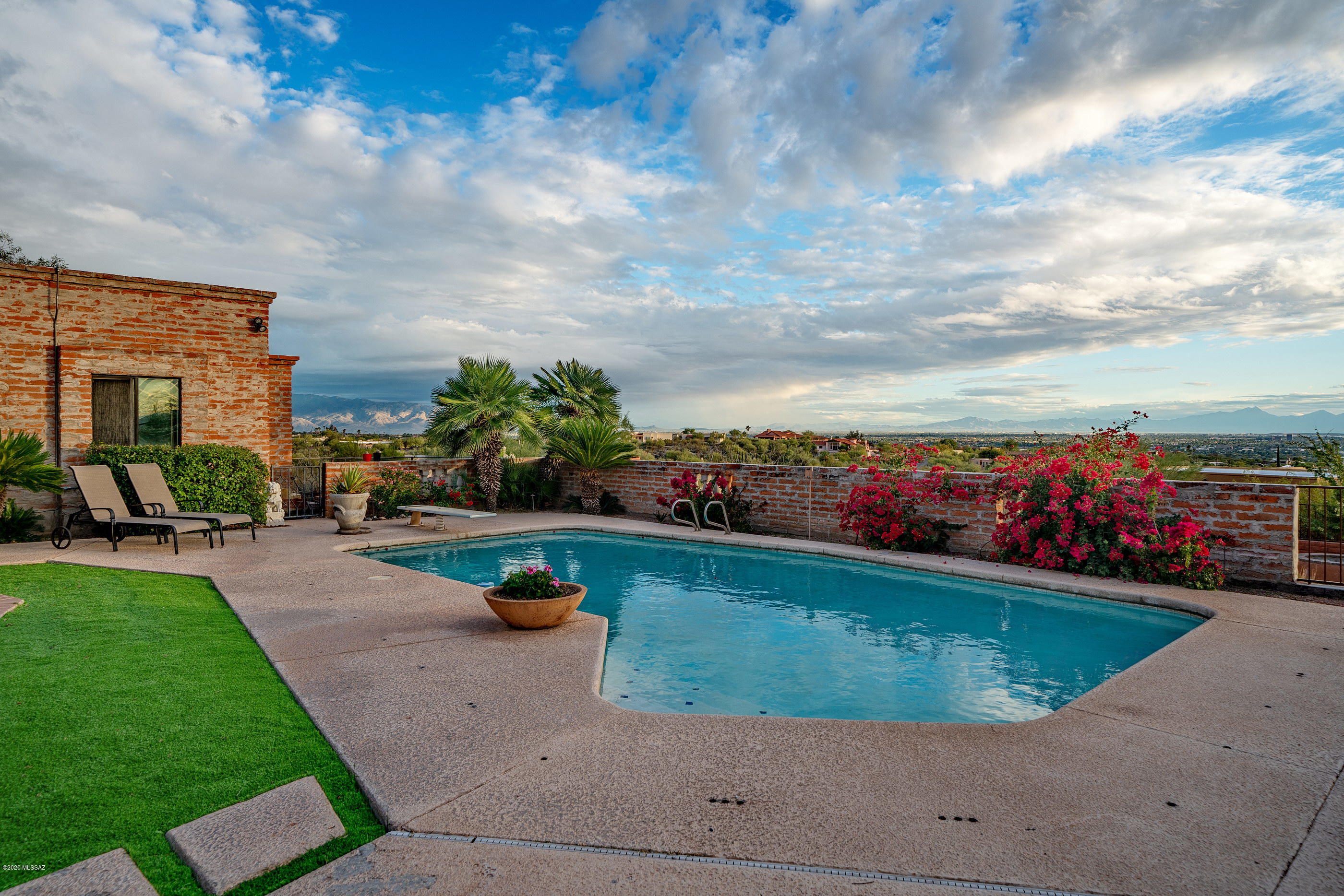 This quintessential Spanish Colonial Palace resides on 2+ acre lot high on a ridge overlooking the valley & city below and 4 mountain ranges. Unobstructed views from Reddington Pass to Sombrero Peak and all the city lights at night. Built of solid Masonry burnt adobe construction outside and with classic, authentic finishes inside: 8' Handcrafted solid wood doors, 12' sahuaro rib beamed ceilings in living areas and tongue & grooved plank ceilings elsewhere; antique tile surrounds and frescoes in cooks island kitchen, along with SS appliances. Floor tile are the rich stained concrete tile found in many original Joessler homes. Oversized Master Bedroom and huge master bath and walk-in closet & walk-in shower. But wait -there's more: a separate but attached office/guest quarters Guest quartes provide bath and separate entrance. This is a gotta see property for the most discerning buyer, looking for an authentic, classic Tucson home!