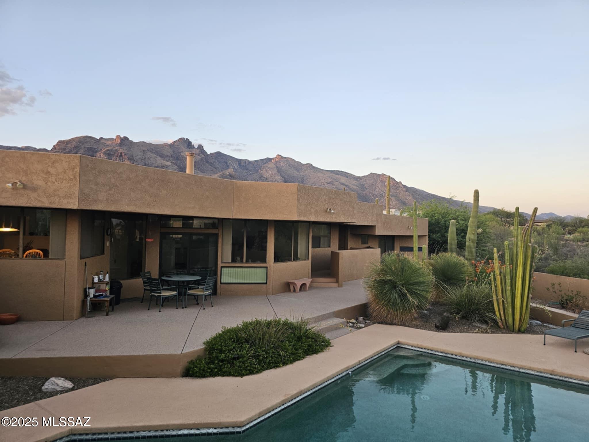 Set on an elevated lot with sweeping city lights and Catalina Mountain views, this beautifully maintained residence blends timeless charm with thoughtful updates and a private, natural setting. Mature desert landscaping surrounds the home, offering exceptional privacy and a tranquil indoor-outdoor lifestyle.

Inside, the open-concept layout features expansive living spaces with high ceilings, abundant natural light, and picture windows framing stunning views. The kitchen is a chef's delight, complete with granite countertops, stainless steel appliances, and an extended breakfast bar perfect for entertaining.

The spacious primary suite is a peaceful retreat with a luxurious bathroom, dual vanities, walk-in closet, and private patio access. Guest bedrooms are generously sized with ample closet space. The home includes a large sized laundry room, lots of storage, and a flexible bonus area ideal for an office, gym, or hobby space.

Step outside to multiple covered patios that capture breathtaking sunsets and city lights. Whether relaxing with a morning coffee or hosting evening gatherings, the outdoor areas are designed for year-round enjoyment.

Located in a quiet established enclave, this home offers a rare combination of seclusion, views, and proximity to shopping, dining, and top-rated schools.