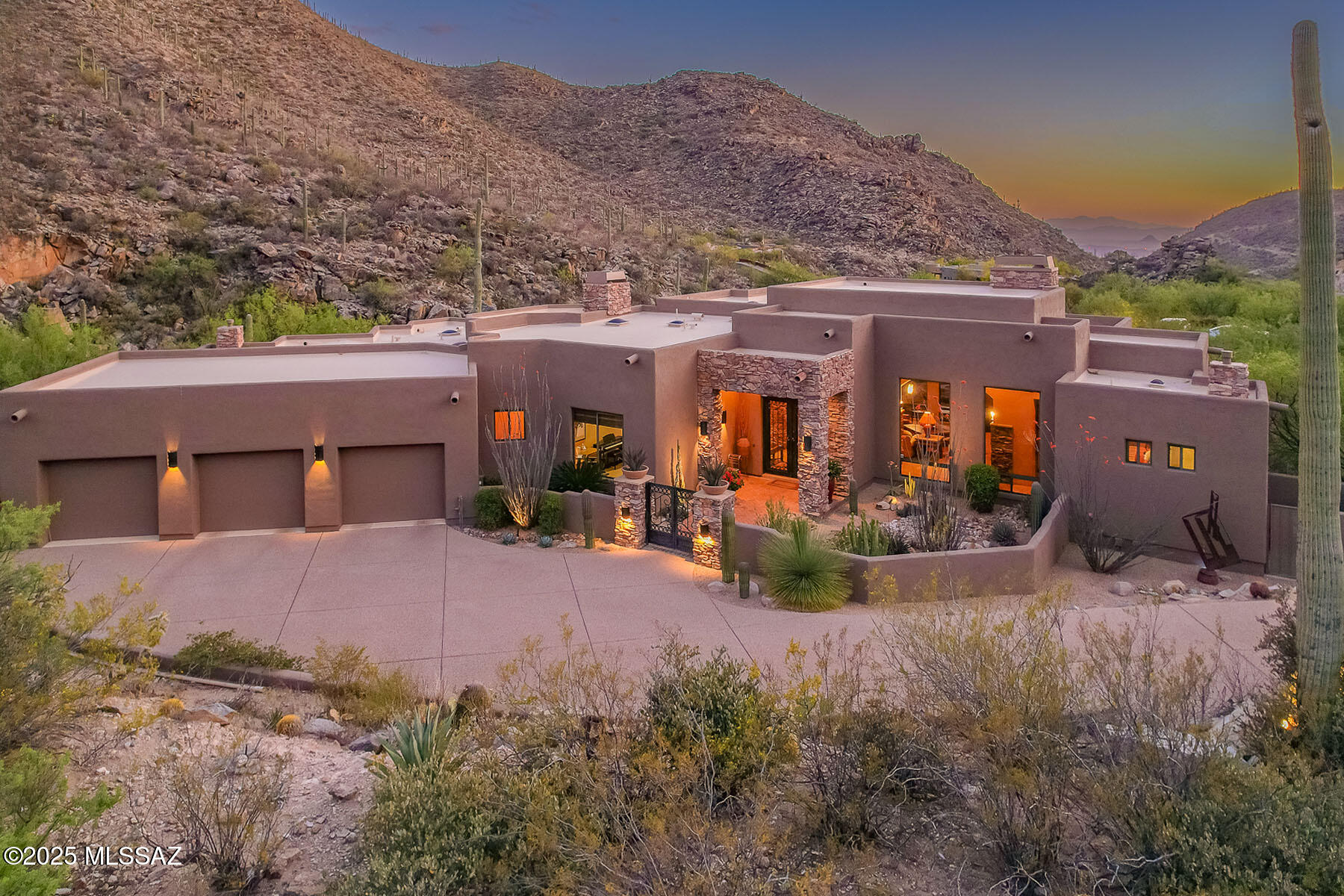 LUXURIOUS CUSTOM ESTATE nestled against the Tortolita Mountains is situated within the exclusive, guard gated community of Canyon Pass at Dove Mountain. Enjoy captivating views of the canyon plus gorgeous desert sunsets. Architectural details, decorator hues and thoughtful amenities abound. This striking 3,016 sq ft residence affords dual ensuite bedrooms, office/third bedroom, 2-1/2 baths, gated front courtyard with fountain plus rear patio hosting outdoor kitchen with dual islands, kiva fireplace and water feature. Wrought iron entry doors open to a spectacular gathering room showcasing a soaring 18' backlit tray ceiling, walls of windows with retractable sunshades, surround sound plus gas fireplace with stacked stone surround flowing to a media wall. Formal dining area with views adjoins a gourmet kitchen hosting granite/SS amenities, large center island with ceramic electric cooktop, wine cooler, 30 lb. icemaker plus built-in refrigerator. Elegant Owner's suite accesses rear patio and hosts a gas fireplace with slate surround, luxury bath with Travertine vanity top, corner soaking tub with slate surround, tiled walk-in shower, custom walk-in closet with dual dressers plus laundry access. Guest room accesses rear patio and offers a tiled walk-in shower, large closet and built-in dresser. Spacious Office or third bedroom boasts a soaring ceiling, dual built-in workstations plus walk-in closet. Storage room or second pantry lies off garage. Countless additional amenities include Travertine floors with wool carpet in bedrooms, custom handmade Alderwood cabinets-dressers-desks, stacked stone interior/exterior columns, 12-16-18 foot ceilings, multiple skylights & art niches, wall art accent lighting, Travertine countertop in laundry, stunning Verde Fire granite countertop in powder room, surround sound and indoor/outdoor ceiling speakers, alarm system, central vacuum plus 3-car garage with storage cabinets. Relax or entertain on the spectacular wraparound, rear paver patio while taking in the breathtaking sunsets and mountain views. Dove Mountain is home to the Ritz-Carlton Resort & Spa, two ICON golf clubs, several sport parks plus hiking/biking trails.