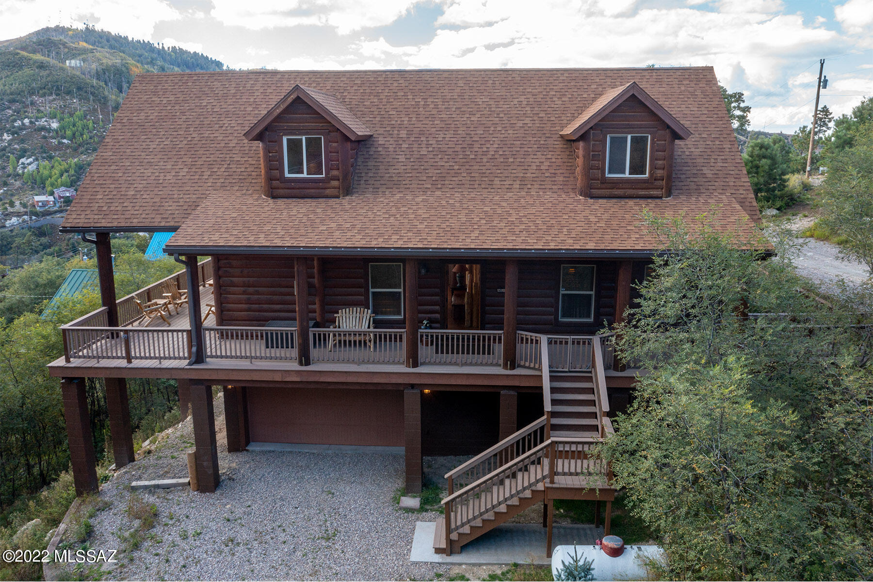 Beautiful turn key whispering creek log cabin home out of Montana. This large cabin is a 2,348 sqft, 3 bedroom 2 bathroom with an open loft. Lot next door is being sold with the cabin (12975 N Yuma Ave) totaling 12,134 sqft. This cabin is being sold fully furnished. Main floor has a nice open floor concept that includes living area, kitchen, dining area, 2 bedrooms and a 3/4 bath. Living area has a large stone gas fireplace to keep you cozy during the winter months. Fully equipped kitchen that overlooks the living and dining area. Beautiful red oak wood flooring on main and bottom floors, carpet in the loft and bedrooms,and tile in bathrooms. VIEWS VIEWS VIEWS! Large wrap around trex deck with amazing views of the Carter Canyon valley. Go upstairs to the open loft and enjoy a game of pool. Downstairs has 1 bedroom, 1 full bath, and a sitting area with a gas stove. 2 car heated garage with a great work area and lots of storage. Cabin is being sold with extra lot, and with the county owned land on one side and no cabin below, this is private setting with great views. Don't miss out on the gem of a cabin!!