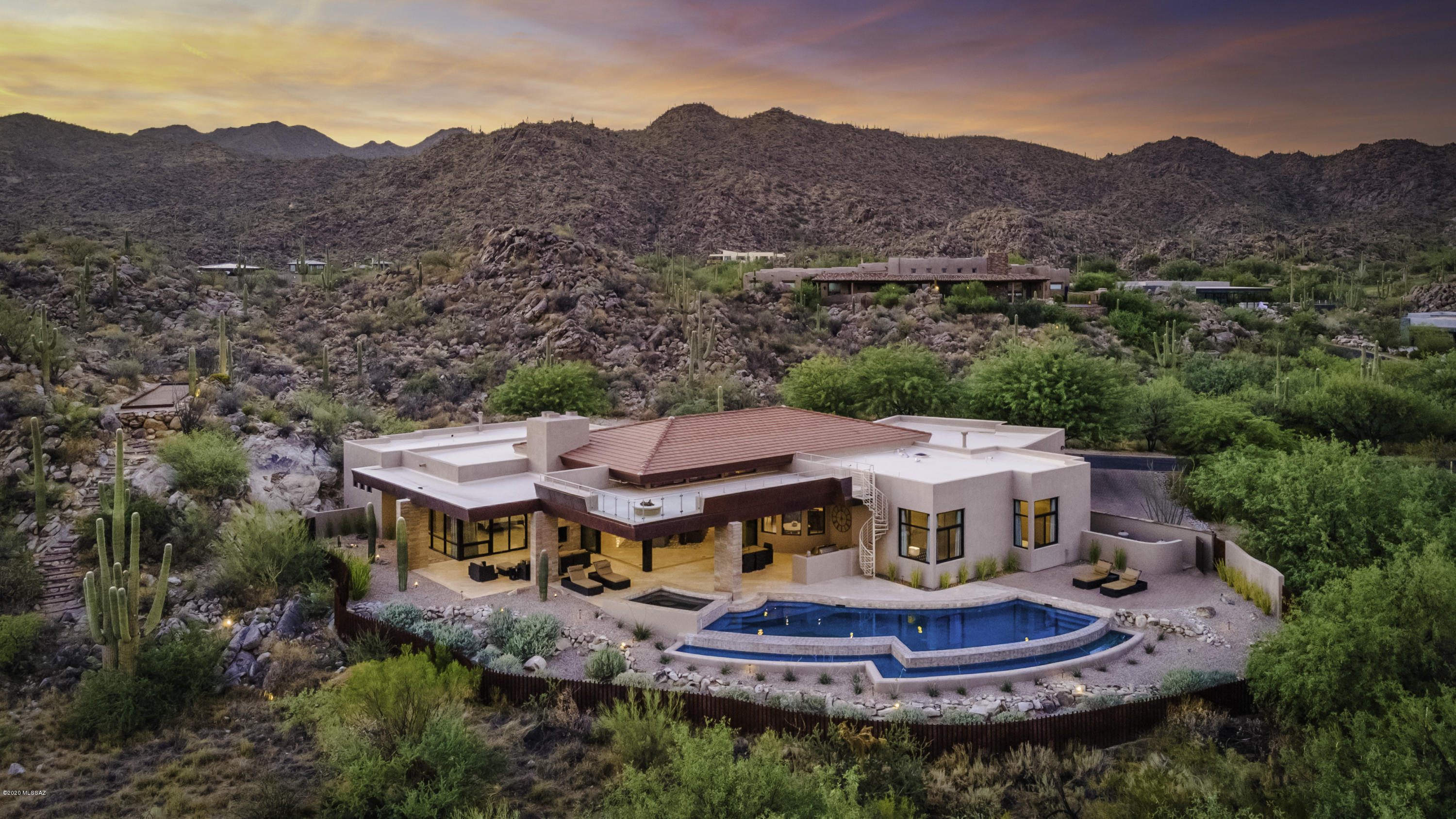 Modern Contemporary With A Flawless Design In Stone Canyon. Overlooking Fairway 13. Nestled against rock outcroppings and surrounded by majestic saguaros with forever views of the  Catalina Mountains and city lights. Walk into a grand wide open great room with breathtaking views. Abundant  kitchen space with Dacor appliances, dual island and a temperature controlled wine room. Sliding glass doors open for a seamless indoor/outdoor experience. Multiple entertaining spaces including roof deck w/ fireplace, glass walls and a jaw dropping view, large covered patio with full outdoor kitchen or retreat outside master patio near the fireplace. Infinity edge pool and spa. Take a walk on the stone stairway to unbelievable viewing patio & bocce ball court. Home is furnished - most from Restoration hardware. Enjoy the feeling of seclusion in this stunning wide open spaces layout.