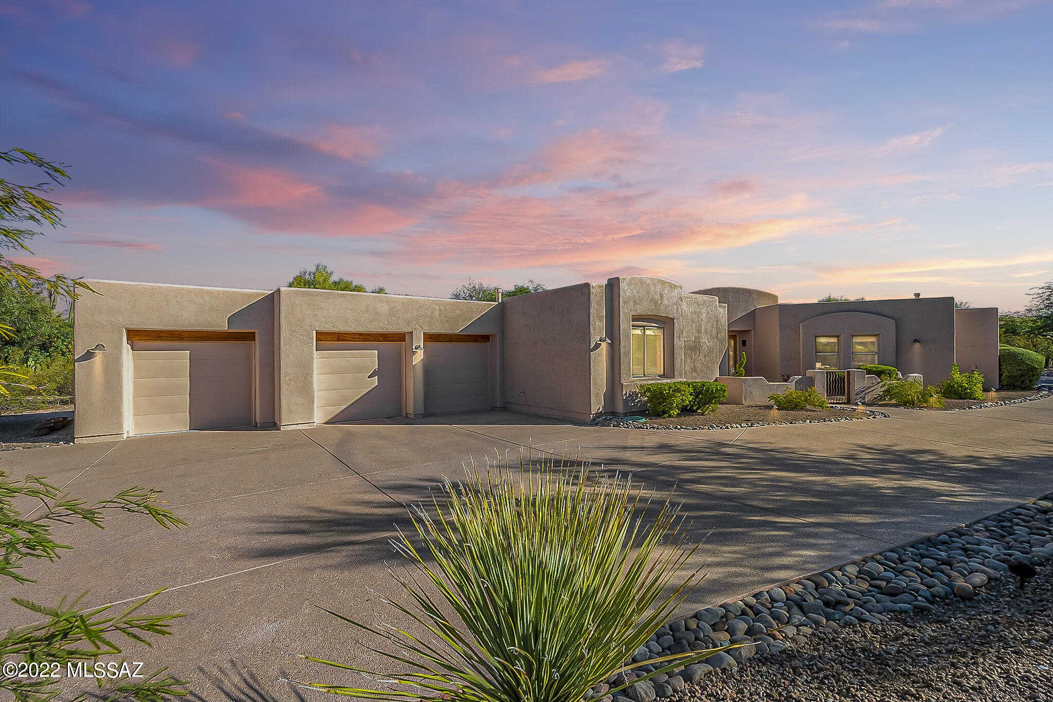 Custom Southwestern Contemporary 4bd/2.5 ba one-story home nestled on nearly an acre in desirable, gated Madera Mesa Estates in Tanque Verde Valley w/mountain views & park-like backyard setting. Enjoy shaded evenings in beautifully landscaped pool sized yard w/wrap around covered patio, brick pavers, built-in hot tub, fenced dog-run & double gate. Sprawling split bedroom plan w/open dining & living spaces, a 4th bedroom set up as an office w/storage & desk built-ins. Kitchen w/valuable storage, SS appliances, gas cooktop & large island w/granite counter. Spacious pantry & laundry, walk-in closets w/ built-ins, gas fireplace, water softener, alarm system. Oversized 3-car garage w/3 lg storage closets & set up nicely for workshop. See attached list of Features and Upgrades for more details!