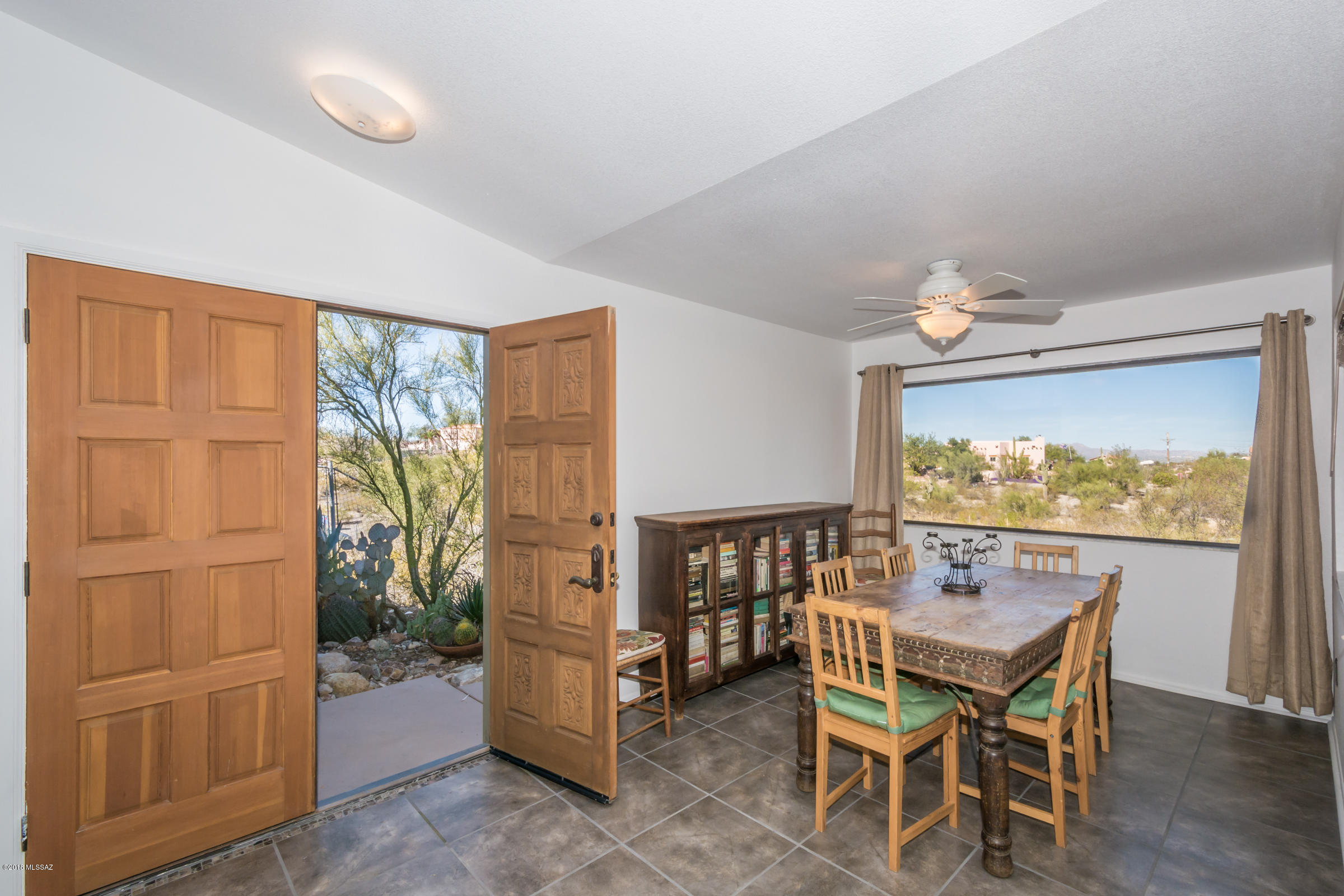 This is a complete view property! From inside and outside the house, there are stellar mountain and panoramic views. It is a true western home with a big rock fireplace, humming birds, butterflies, wildlife and trails close by. It is very convenient to the Sweetwater Preserve, downtown, the University of Arizona etc. The home is light and airy with great picture windows framing the views and big skylights adding natural light. The kitchen was remodeled less than two years ago and it features granite counters and granite back splashes, stainless steel appliances and more. All of this on an acre plus of land on a cul de sac tucked away for beauty and privacy.
