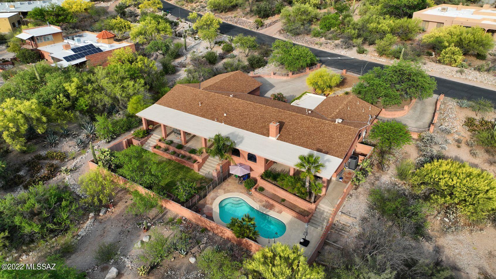 Perfectly situated on a quiet neighborhood street, this ranch-style home offers tranquility, privacy and stunning Catalina Mtn views. Swim in the pool or enjoy a meal on the extended elevated patio. With an abundance of space you'll find room for everyone!  New roof  overlay on entire house and coating 2022. New water heater in 2022! Brick fireplace adjacent to the kitchen. Living and dining rooms have oversized windows overlooking the lovely landscaped front yard. All beds/bathrooms are on one level. Don't miss the additional flex space down the short flight of stairs! Perfect for so many uses. Oversized laundry room and right off of that is a second large studio/office/flex space. Call today for your private showing!