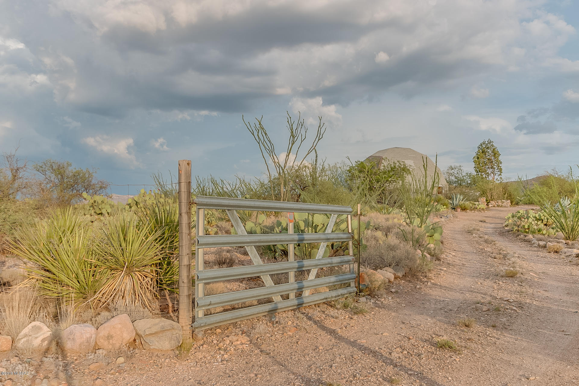 This breathtaking dome-shaped home boasts a surprising amount of space, with nearly 1700 sf, 2 large bedrooms and 2 full baths.  Three large glass entries on the bottom level allow a variety of access and tons of natural light into the great room, while geometric skylights allow you to watch the clouds morph overhead.  Master bathroom features dual sinks and a 2-person jetted tub.  A spiral staircase leads you to a generous second bedroom and second full bath.  The home sits on nearly five acres of pristine natural landscape, with far-reaching mountain views in every direction.  If you look close, you will spot A-Mountain and downtown Tucson in the distance.  You would be hard-pressed to find a property more stunning and serene than this.