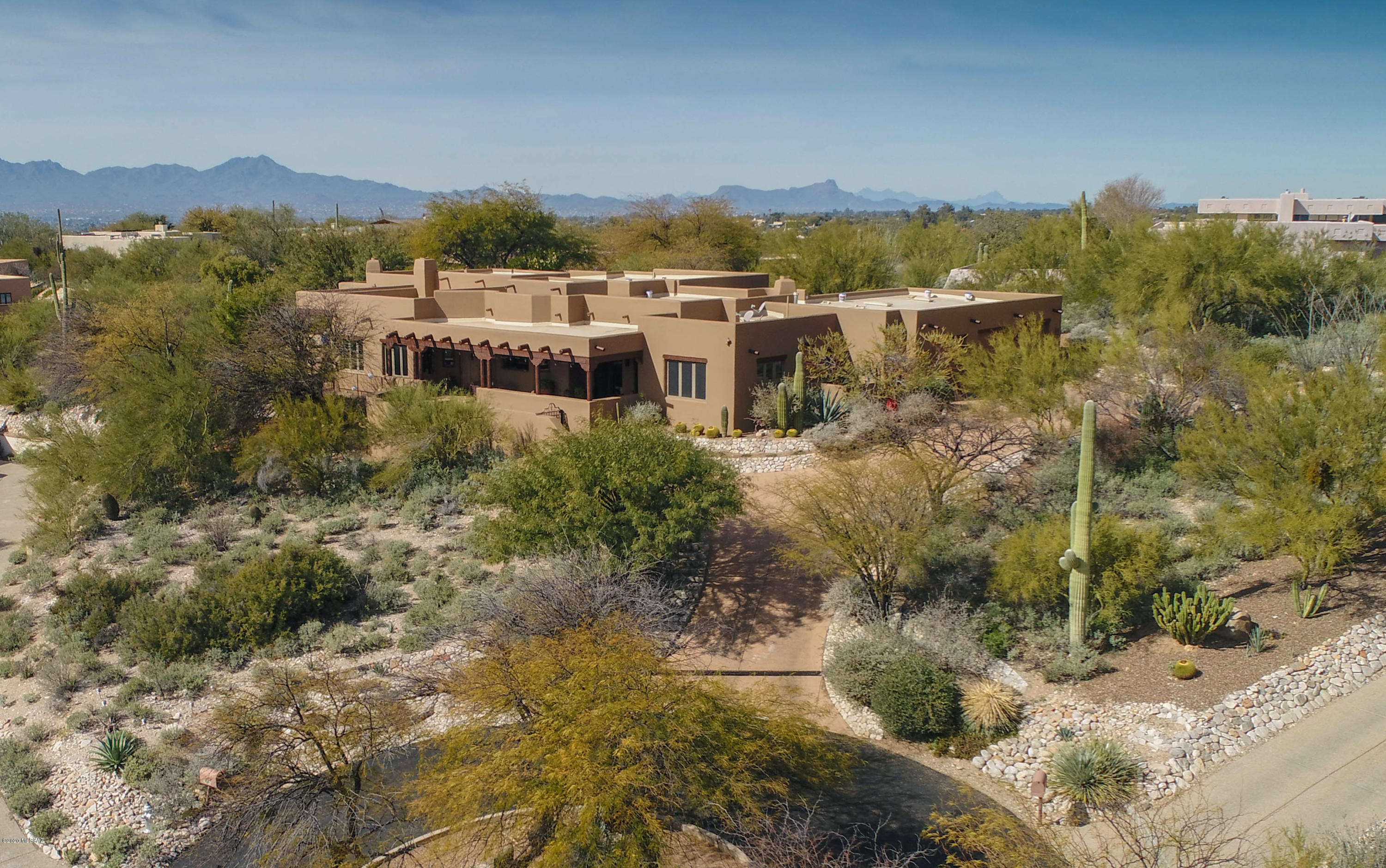 Authentic  Santa Fe style home in gated La Paloma Estates.  This custom built home is located at the end of a cul-de-sac, on a high ridge top with unobstructed panoramic views of the city lights and surrounding mountains.  Every square foot shows the highest quality of construction and finishing touches.  From the hand troweled stucco finish, to the vega beam and pealed alder wood latilla ceilings, solid cedar doors with European hardware. The kitchen features a large center island, cherry cabinets, high-end stainless appliances, and built-in desk area.  The spacious master suite features a separate sitting area with fireplace, and huge master bath and closet.  Four covered patios provide  outdoor living space. Multiple level yard features a pool, spa, and exceptional landscaping.