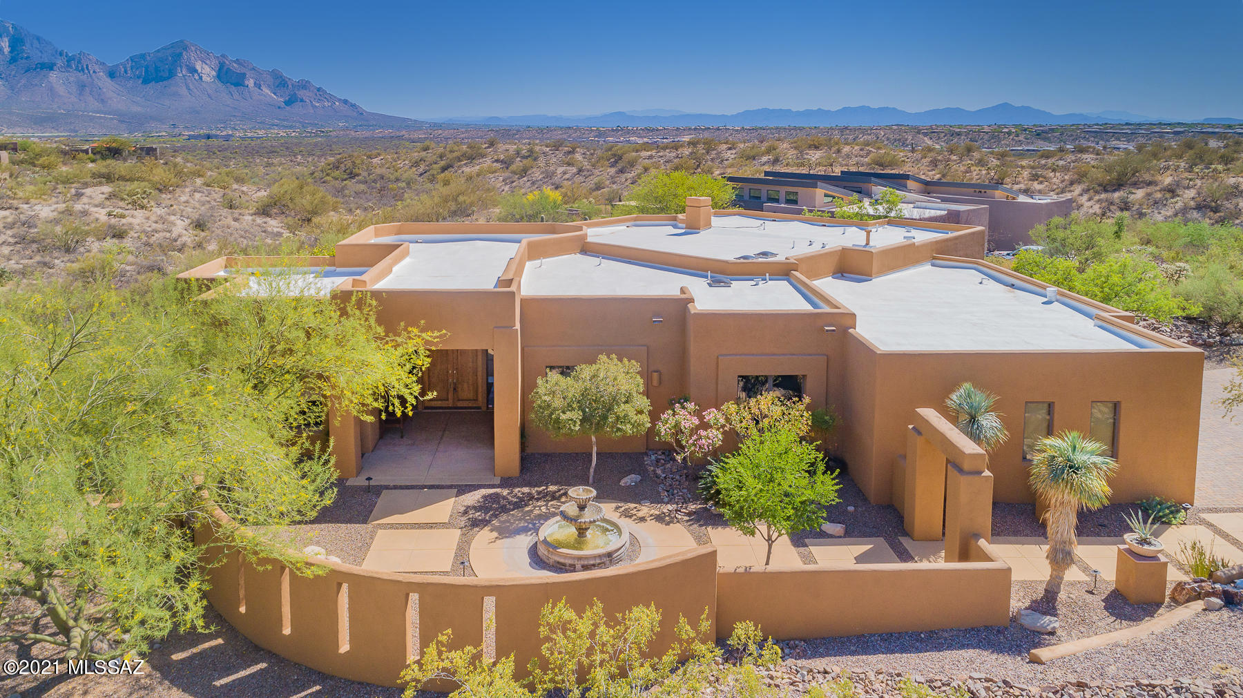 Spectacular SW contemporary w/wrap around Mtn, Sunset & some City views. Arched entries, domed hallways & dramatic high ceilings are found throughout. Impeccably maintained & updated w/high end products & finishes. The kitchen is designed w/the chef & entertainer in mind w/an abundance of cabinetry, walk-in pantry, S.S. appliances to include a gas cooktop, double ovens & a wine frig. The inviting Family rm offers a corner kiva fireplace & built-in entertainment ctr w/storage. Huge Mstr suite w/bayed sitting area & luxurious bthrm retreat. Pamper your guest w/private guest suite w/large walk-in shower. The resort style yard is lushly vegetated w/a mix of low care & mature citrus & Mesquite trees enhancing the pebble tec pool & spa. Extended patio w/BBQ center. Magnificent Views.