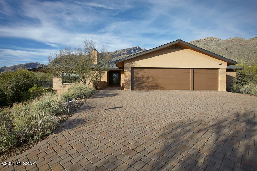 Enjoy panoramic views from almost every window in this exquisitely remodeled home in Coronado Foothills Estates. The 3000 sq. ft, 4BR/3BA house with a large yard and pool is sited to capture the beauty of the mountains, desert & sunsets. Custom features include a wrought iron & glass front door, vaulted ceilings, Brazilian slate counter tops, cherry cabinets, radiant heat floors in BA's, alder doors & metal roof. The main level has a spacious LR w/gas FP, DR, gourmet kitchen w/breakfast bar, 2BRs +office/or 3rd BR, laundry & 3 car garage. The lower level w/family room, BR and full BA offers privacy for guests. Enjoy the best of Tucson casual living in the spacious yard w/pool or on one of the decks watching the sunset! District 16 schools, conveniently located & voluntary HOA