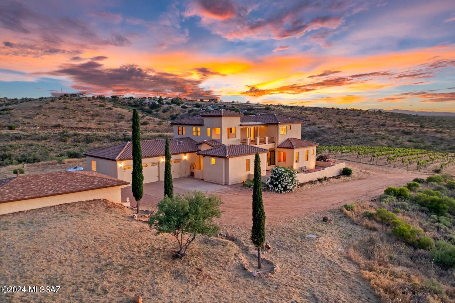 Range Priced $978,800 - $1,008,000 Discover the charm of the Pinal County countryside with this stunning 10-acre Tuscan-style Estate, complete with its own vineyard boasting 600 vines—50% Merlot, 25% Tempranillo, and 25% Chardonnay. Equipped with all the necessary tools to produce your own wine, including a spacious, air-conditioned/heated outbuilding with a garage door, this property offers an unparalleled winemaking experience.
The 3200 sqft main house features a luxurious primary suite, and two ensuite bedrooms (one ideal for an office). The elegant layout - taking advantage of 360 degree views - includes a large living room, dining room, and two screened-in porches, perfect for enjoying the scenic surroundings.  The majestic front patio welcomes you, while the back patio patio is an entertainers dream, complete with a potential outdoor BBQ area set-up and an enchanting olive grove. Additionally, a separate guest casita offers a cozy bedroom, ensuite bath, and his/her closets, proving a perfect private retreat for visitors. Experience the beauty and serenity of this unique fully fenced, with gated entry property in Oracle, AZ!  Your Tuscan paradise awaits!